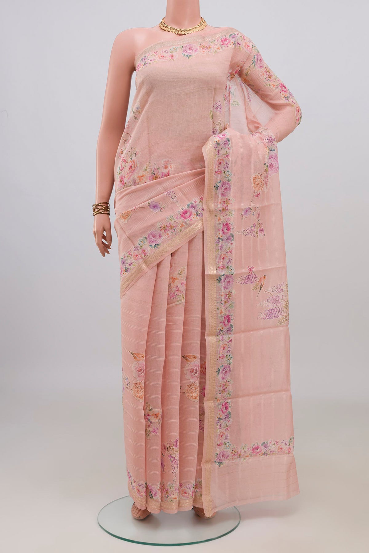 Peach Tussar Saree with Floral Print on the body and Thin Zari Line.  displayed on a mannequin