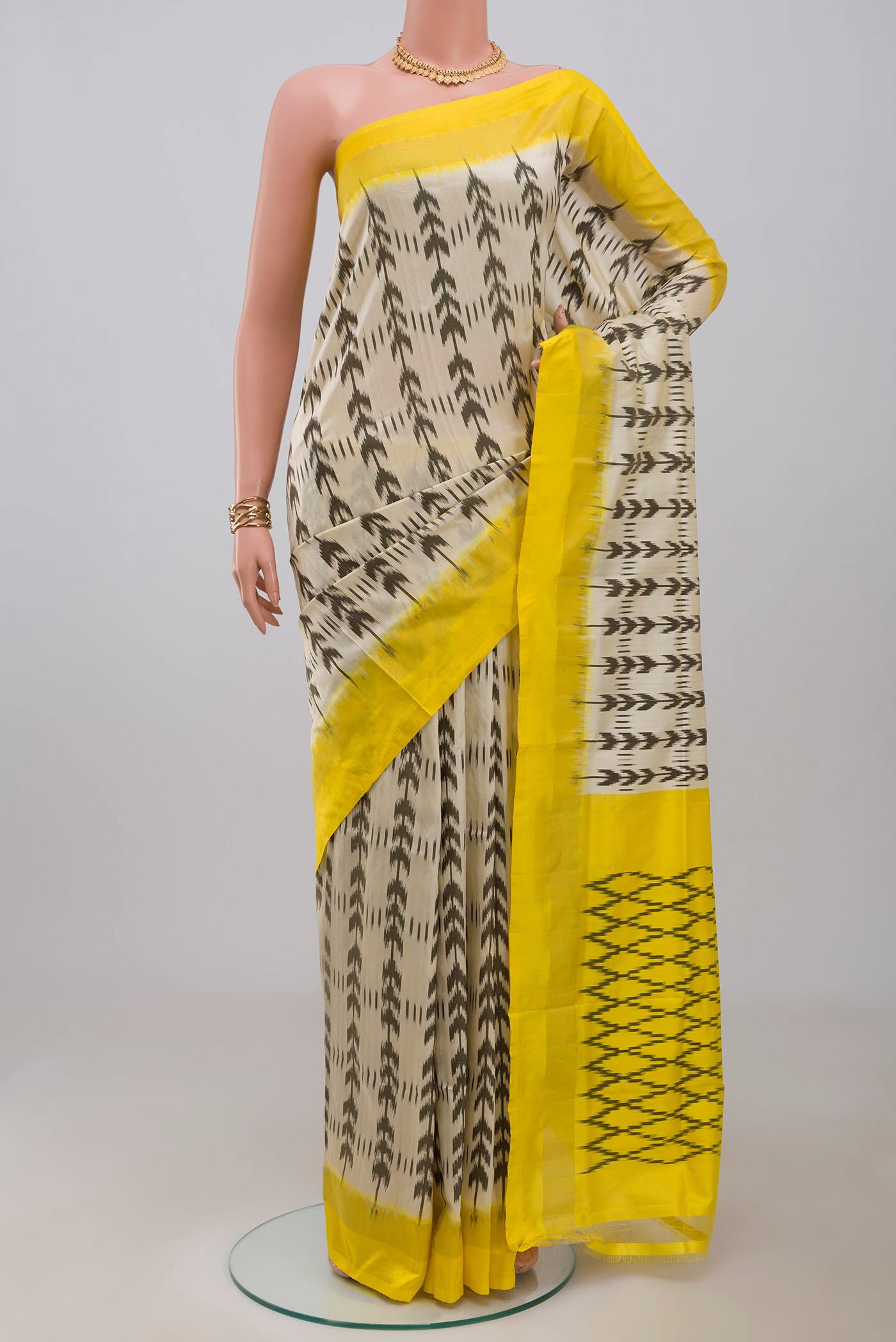Cream Pochampally Saree with Ikat design on the body and Thin Zari Line.  displayed on a mannequin