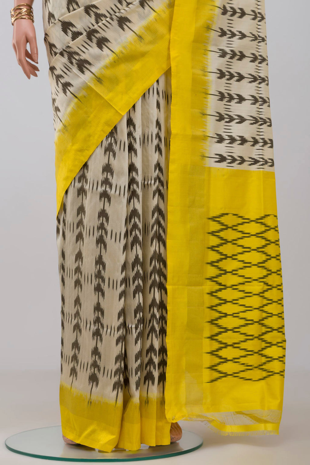 Pleats and pallu of Cream Pochampally Saree with Ikat design on the body and Thin Zari Line. 
