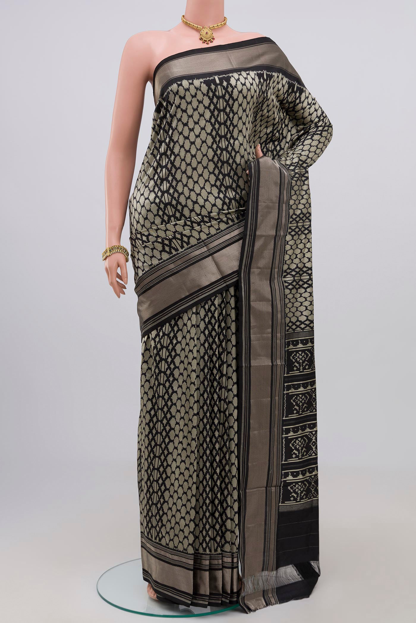 Black Pochampally Saree with Ikat design on the body and Zari Border.  displayed on a mannequin