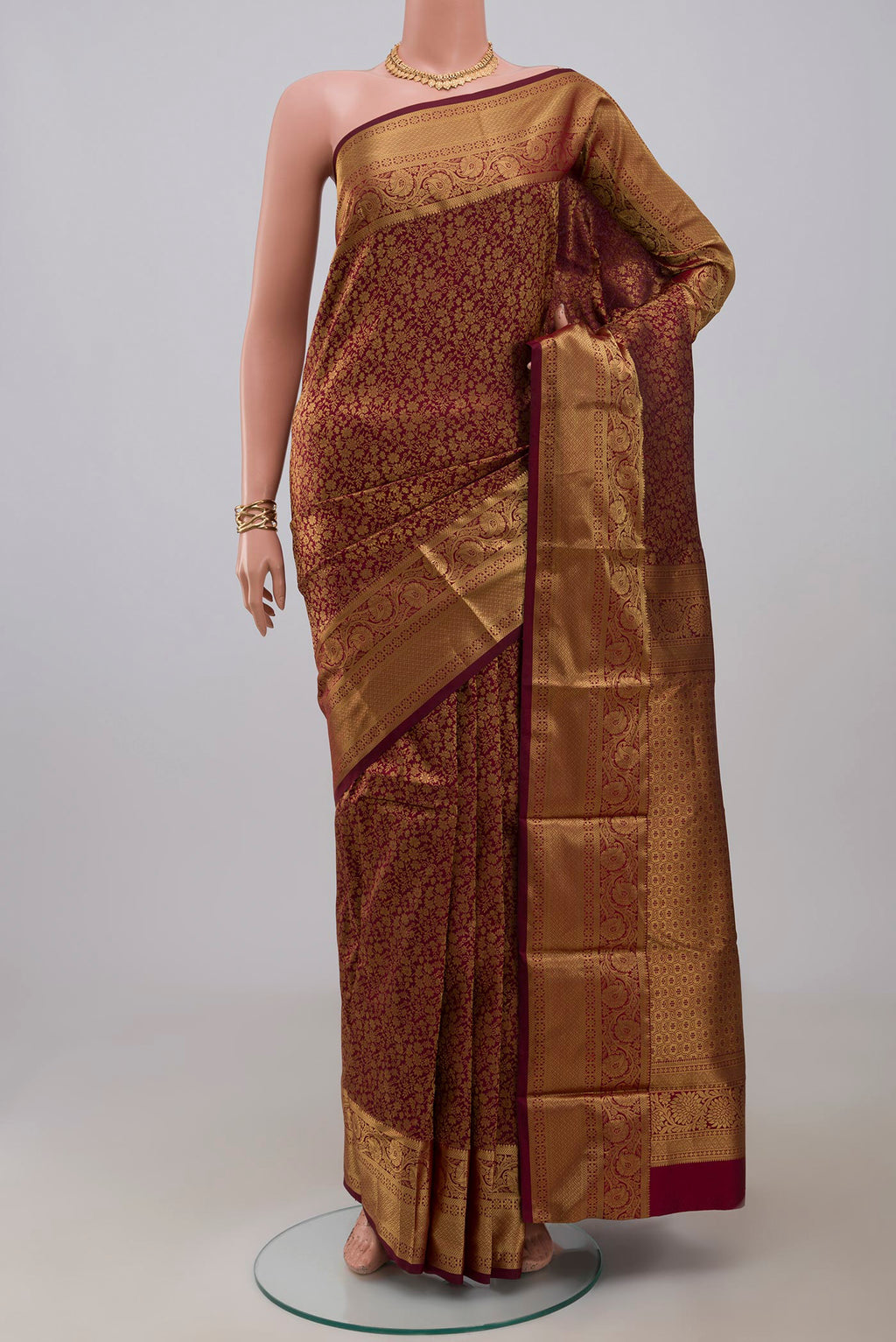Maroon Kanjivaram Silk Saree with Zari Brocade on the body and Zari Border.  displayed on a mannequin