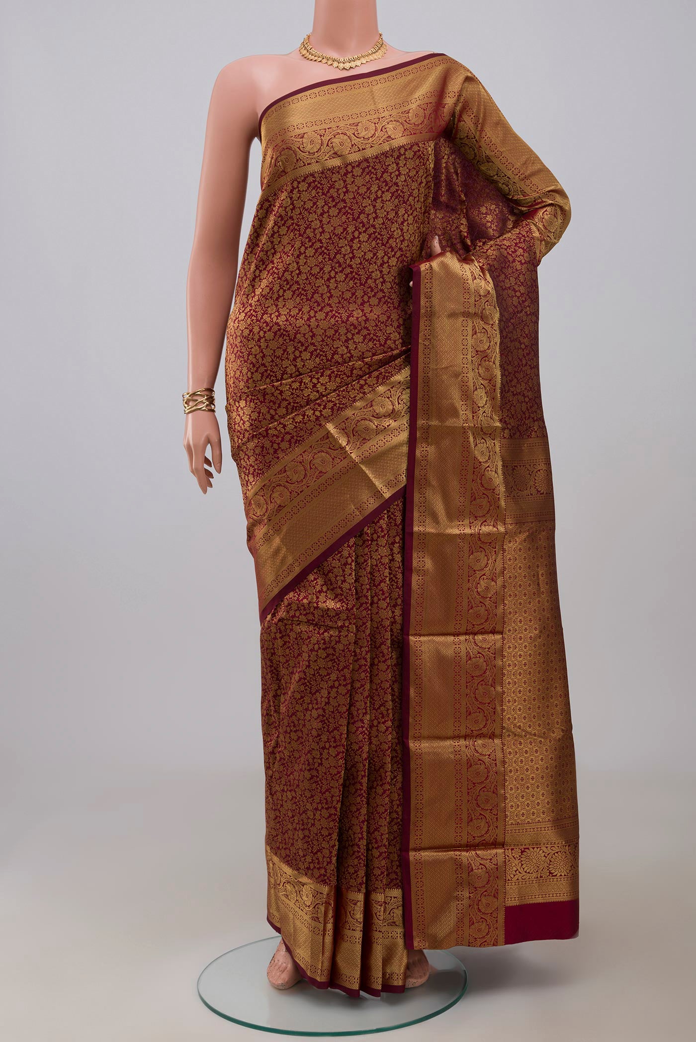 Maroon Kanjivaram Silk Saree with Zari Brocade on the body and Zari Border.  displayed on a mannequin