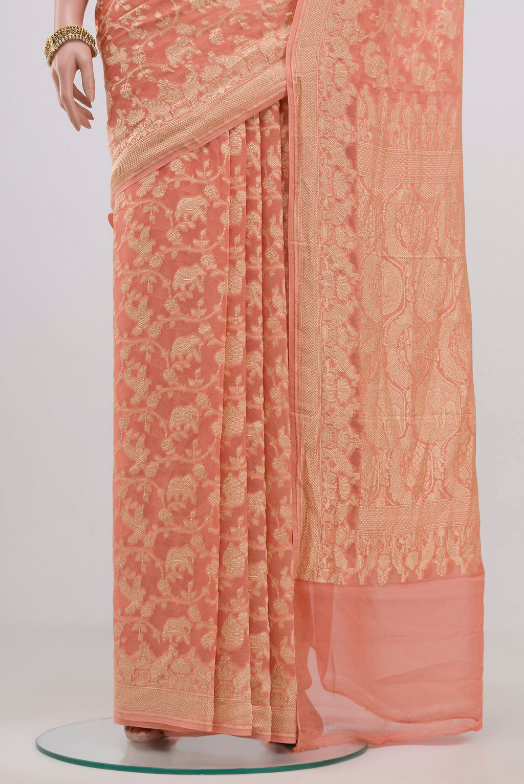 Pleats and pallu of Peach Georgette Saree with Fancy on the body and Zari Border. 