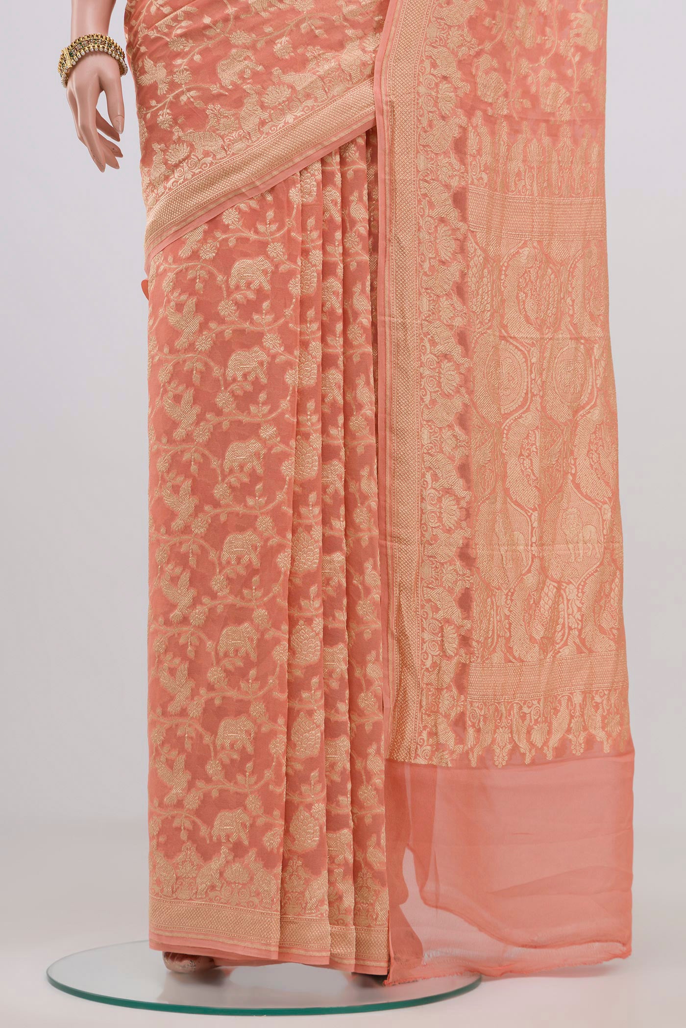 Pleats and pallu of Peach Georgette Saree with Fancy on the body and Zari Border. 