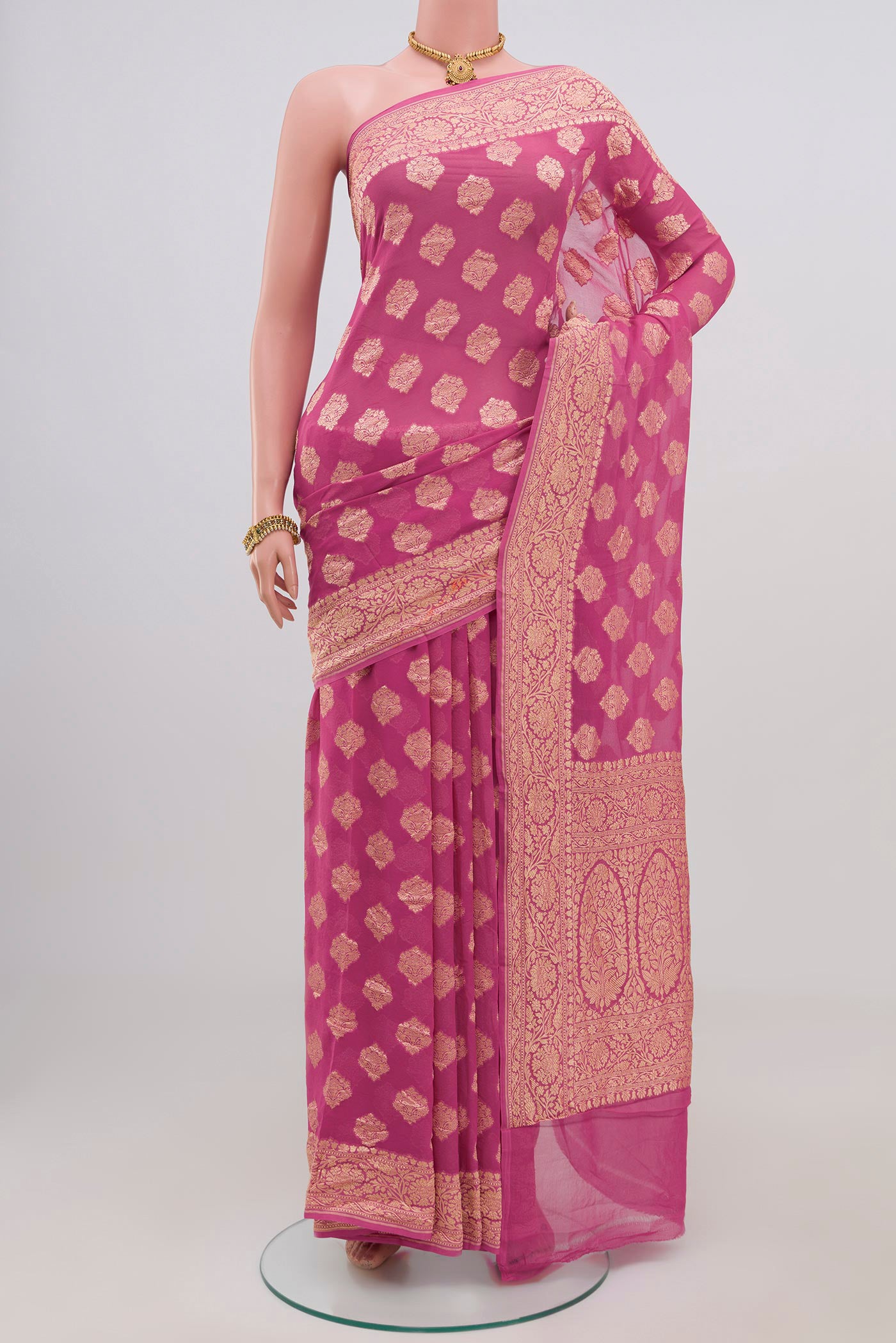 Pink Georgette Saree with Zari Butta on the body and Zari Border.  displayed on a mannequin