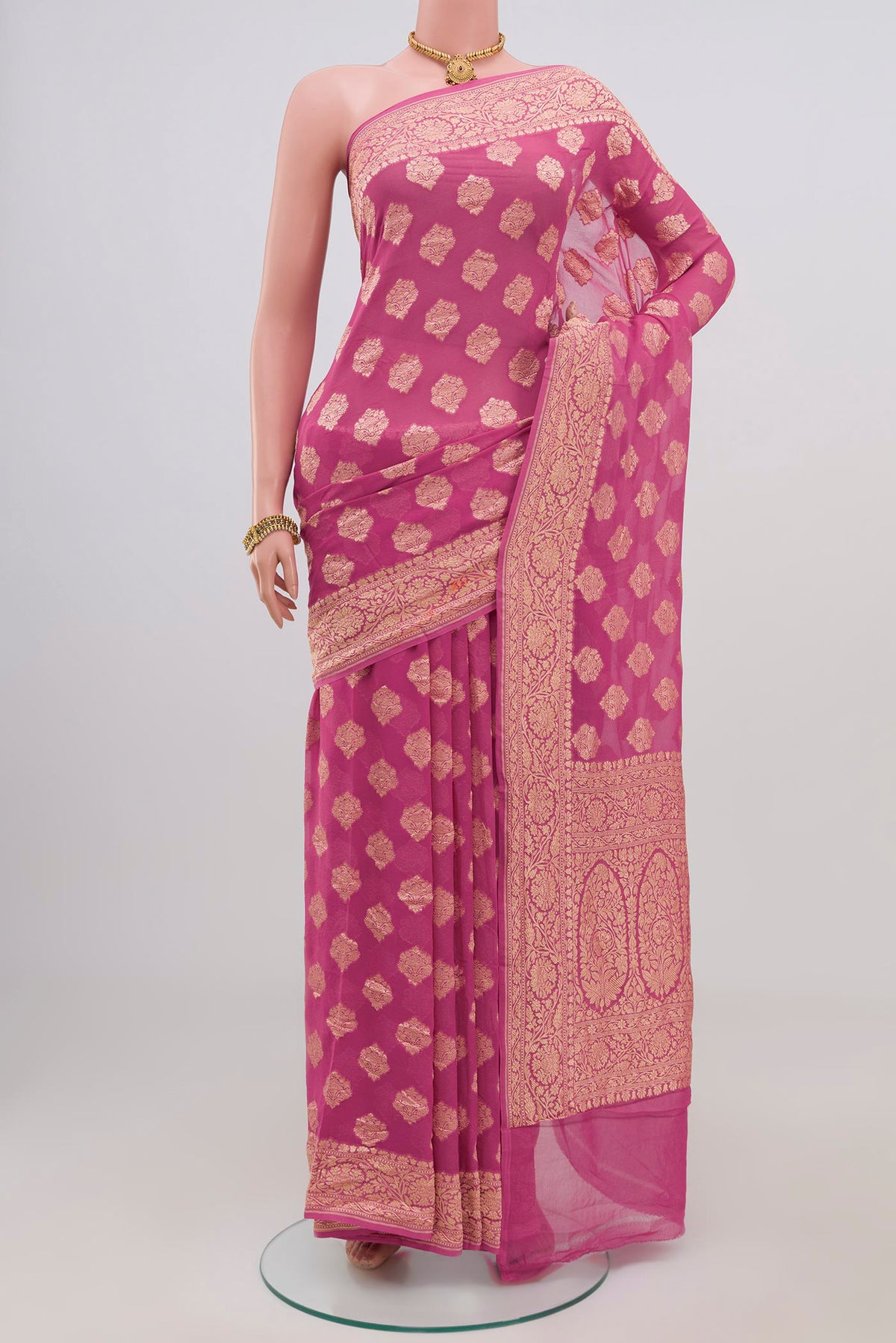 Pink Georgette Saree with Zari Butta on the body and Zari Border.  displayed on a mannequin