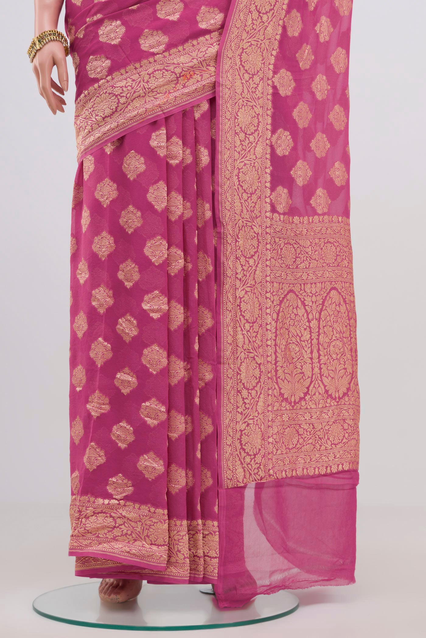 Pleats and pallu of Pink Georgette Saree with Zari Butta on the body and Zari Border. 