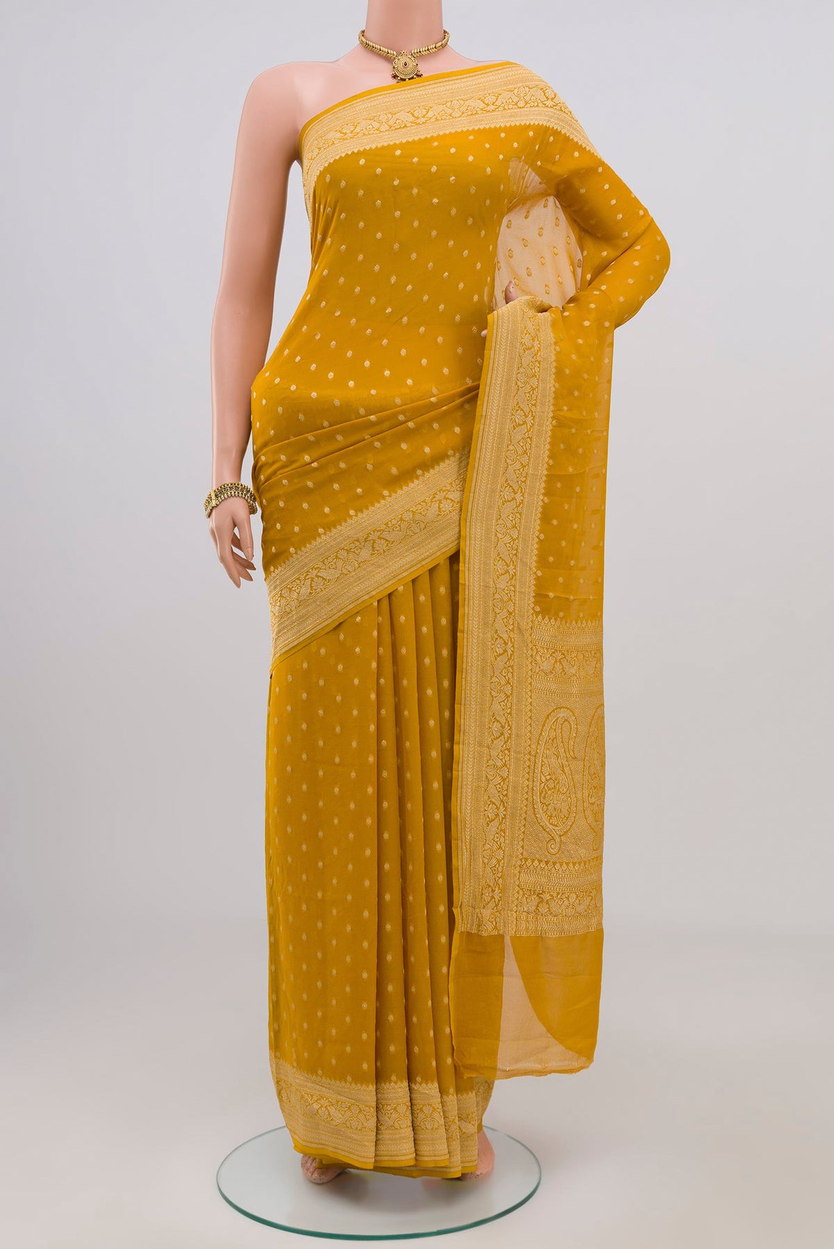 Yellow Georgette Saree with Zari Butta on the body and Zari Border.  displayed on a mannequin