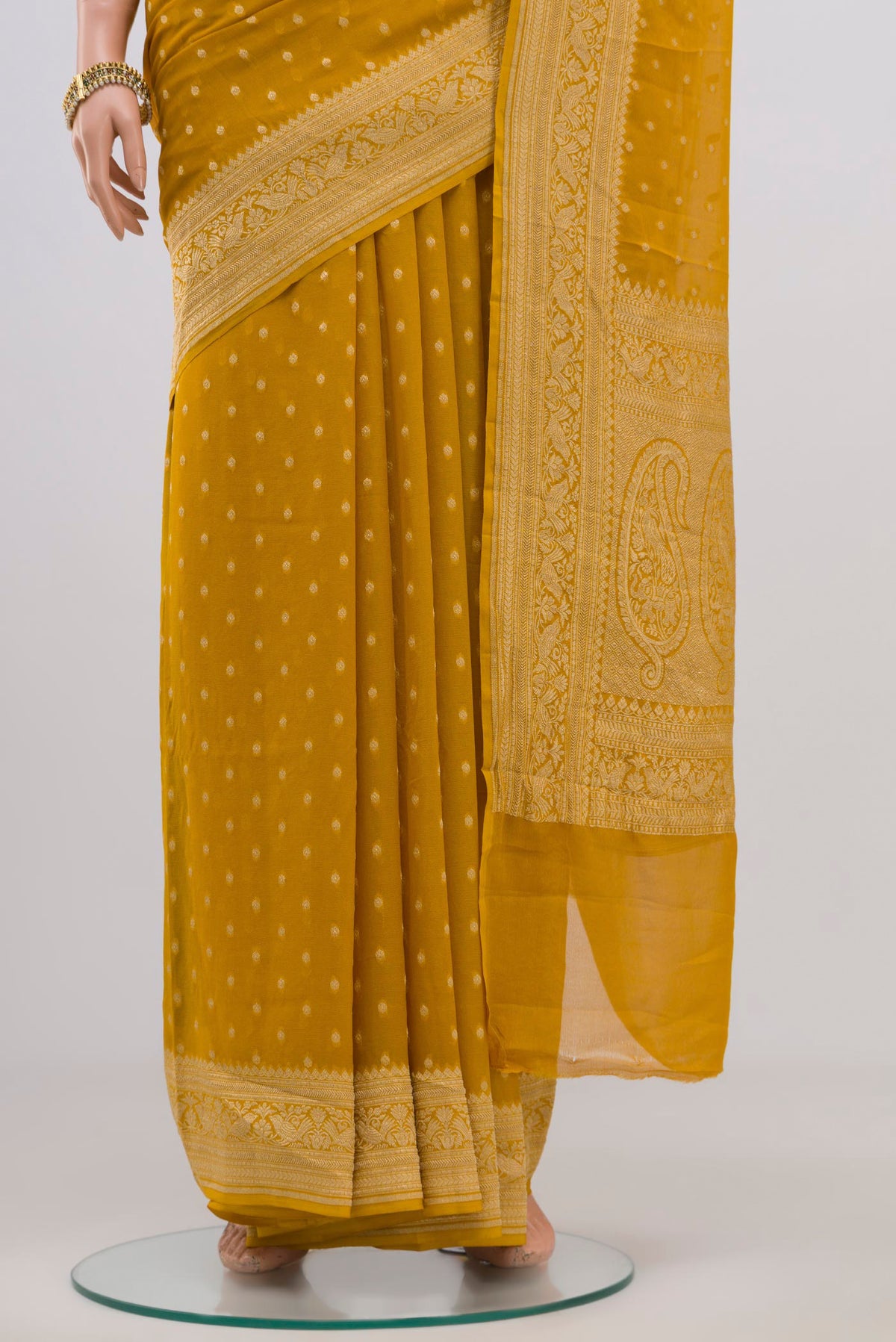 Pleats and pallu of Yellow Georgette Saree with Zari Butta on the body and Zari Border. 