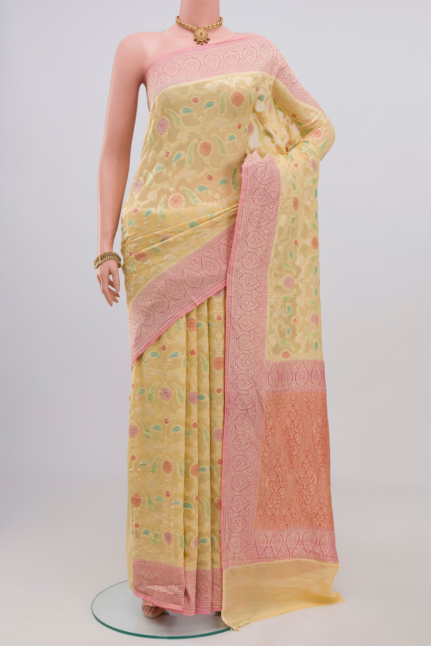 Yellow Georgette Saree with Fancy on the body and Zari Border.  displayed on a mannequin