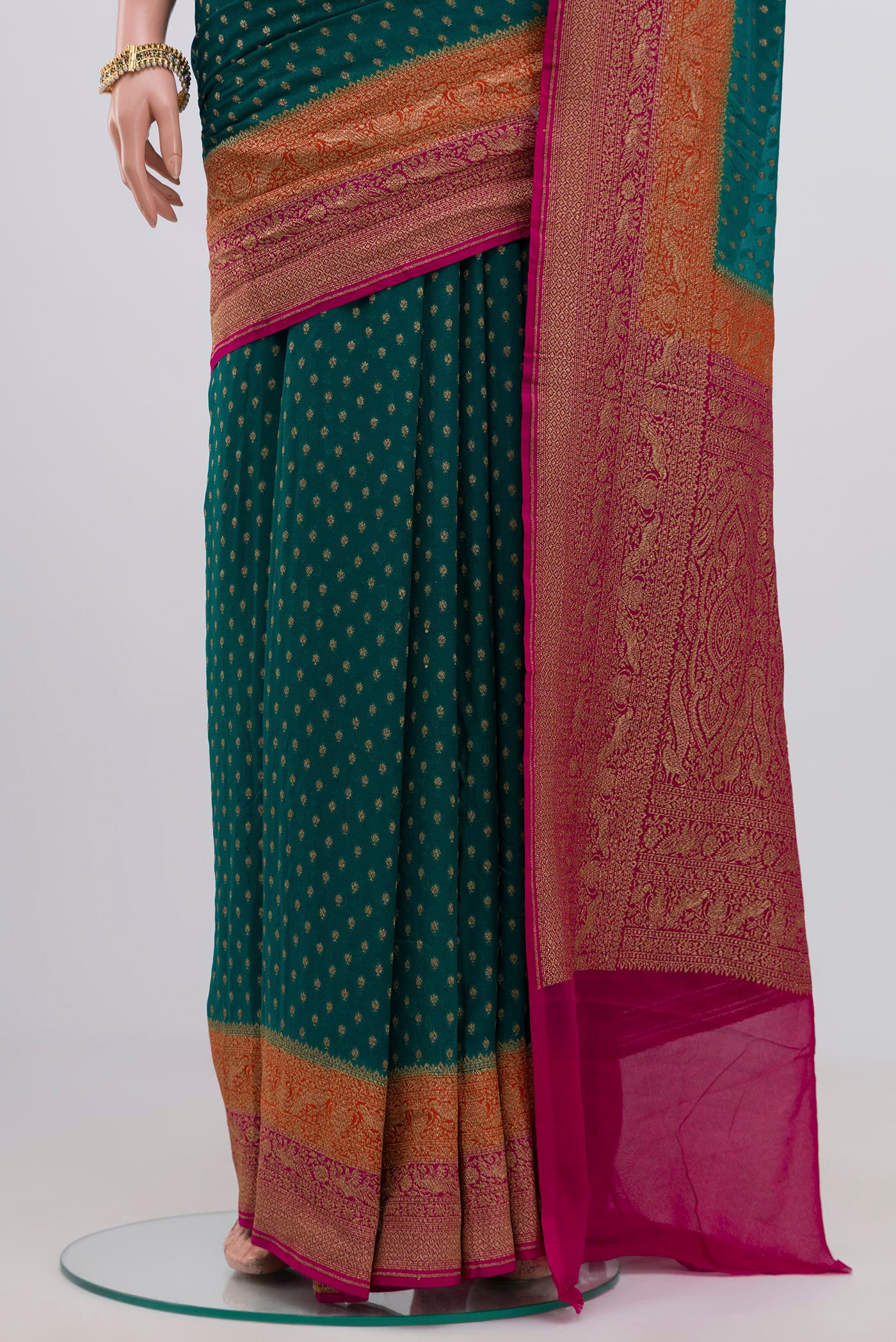 Pleats and pallu of Green Georgette Saree with Zari Butta on the body and Zari Border. 