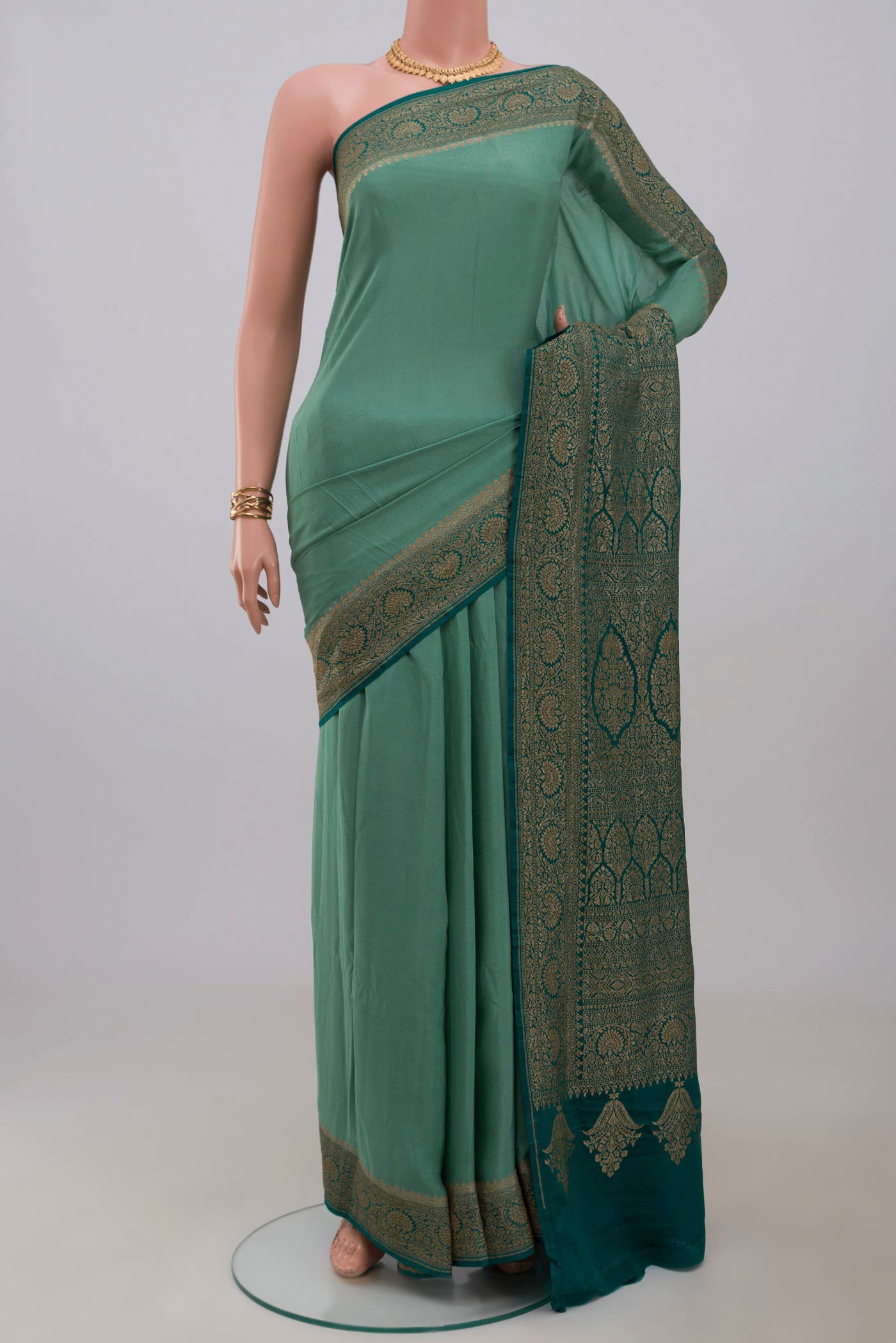 Sea Green Georgette Saree with Plain Body and Fancy Border.  displayed on a mannequin