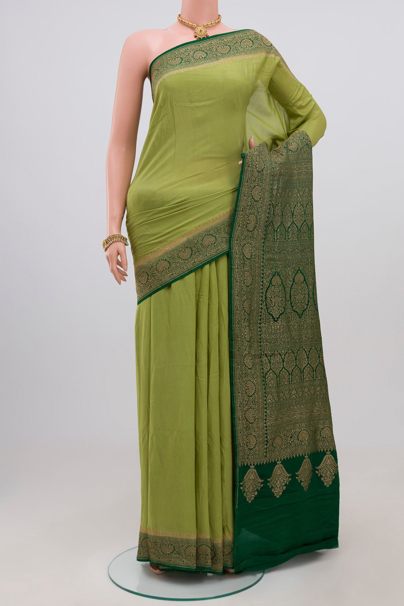 Light Green Georgette Saree with Fancy on the body and Zari Border.  displayed on a mannequin
