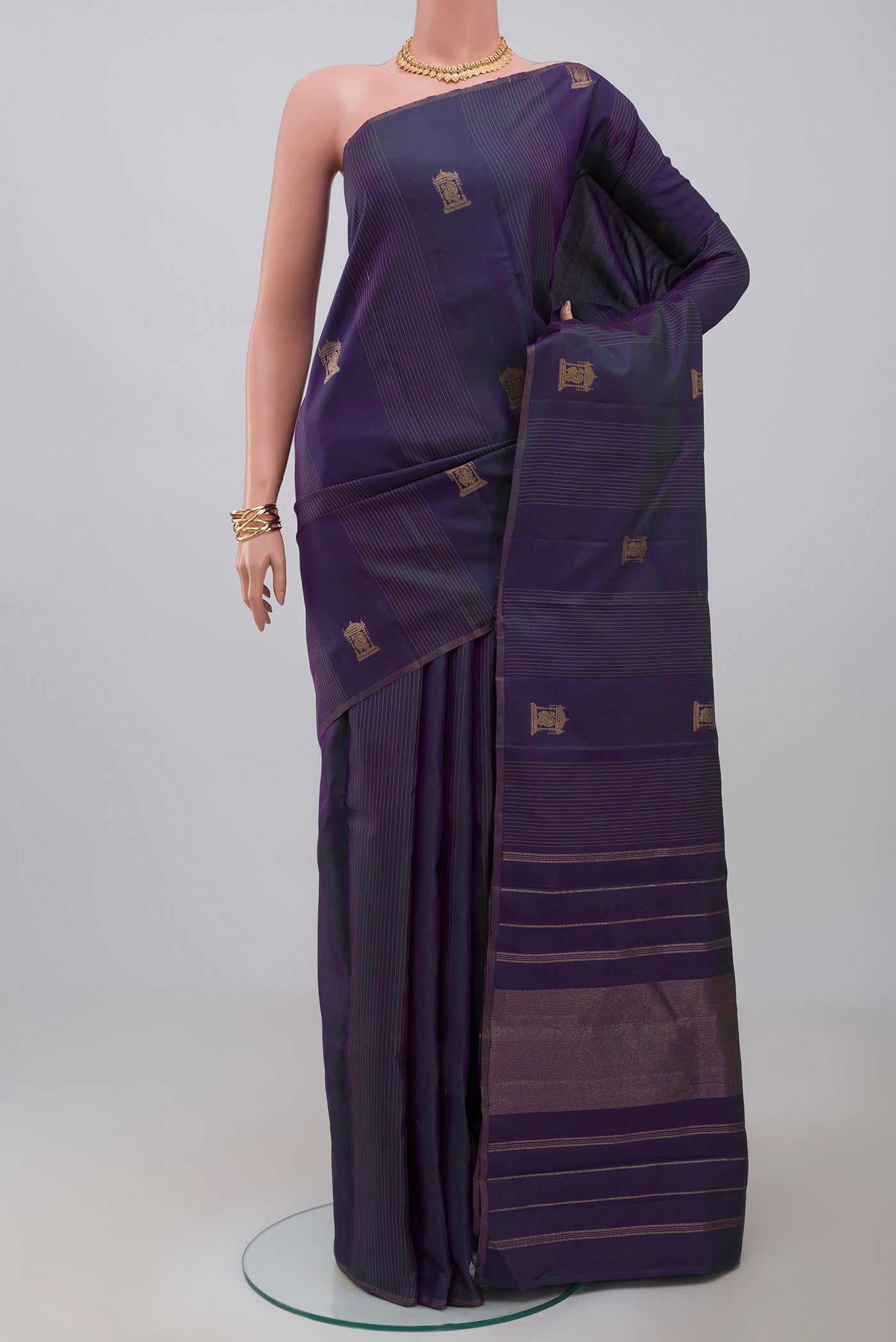 Pure Silk Pure Zari Purple Kanjivaram Saree with Zari Butta on the body and Thin Zari Line.  displayed on a mannequin