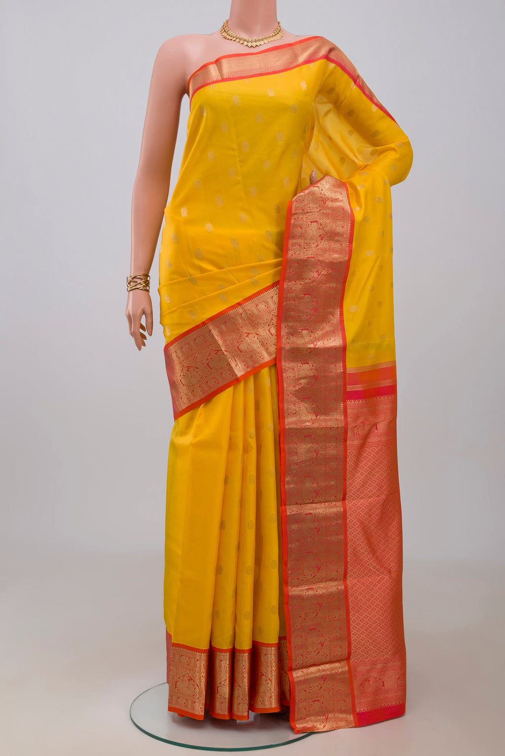 Yellow Kanchipuram Silk Saree with Zari Butta on the body and Zari Border.  displayed on a mannequin
