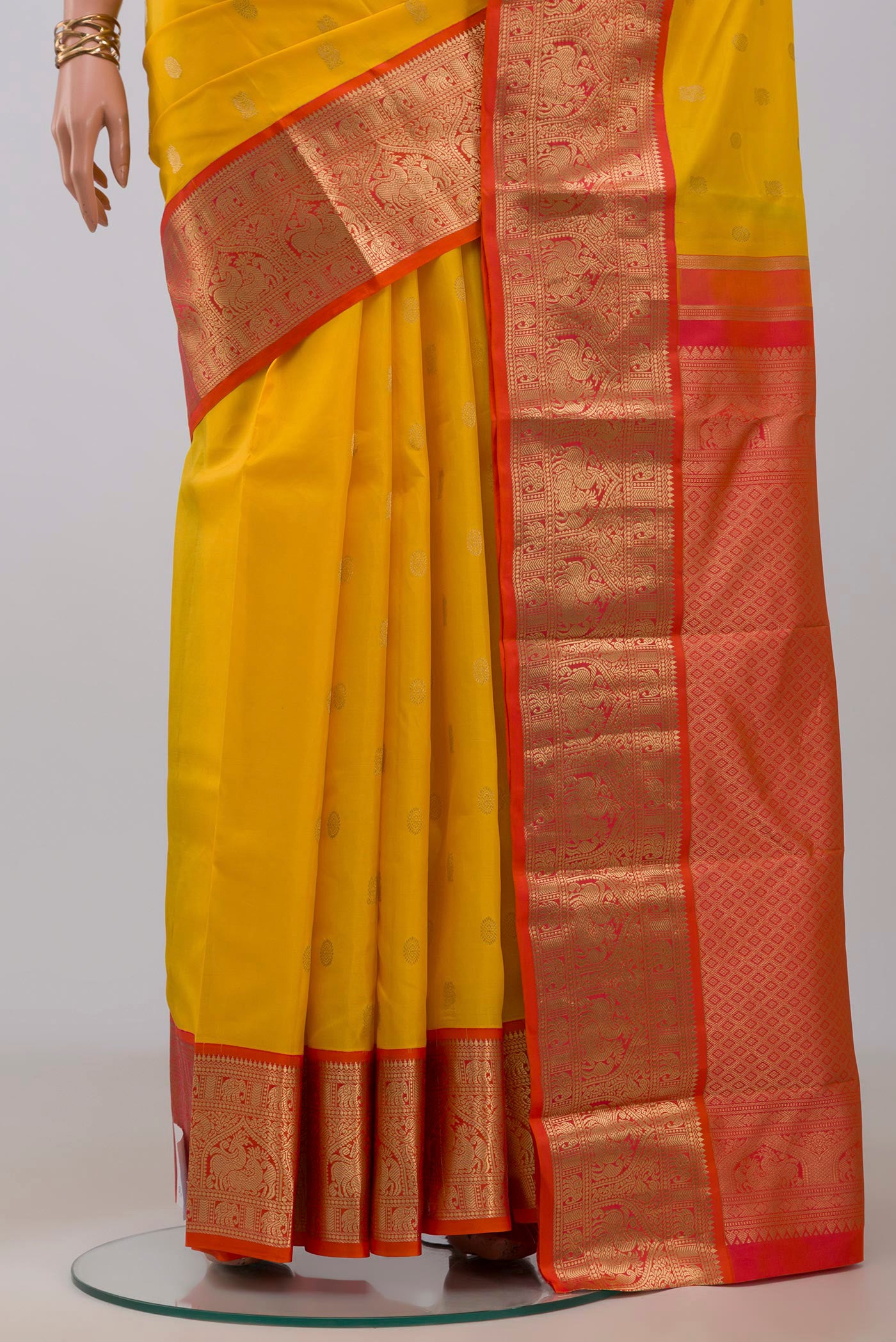 Pleats and pallu of Yellow Kanchipuram Silk Saree with Zari Butta on the body and Zari Border. 