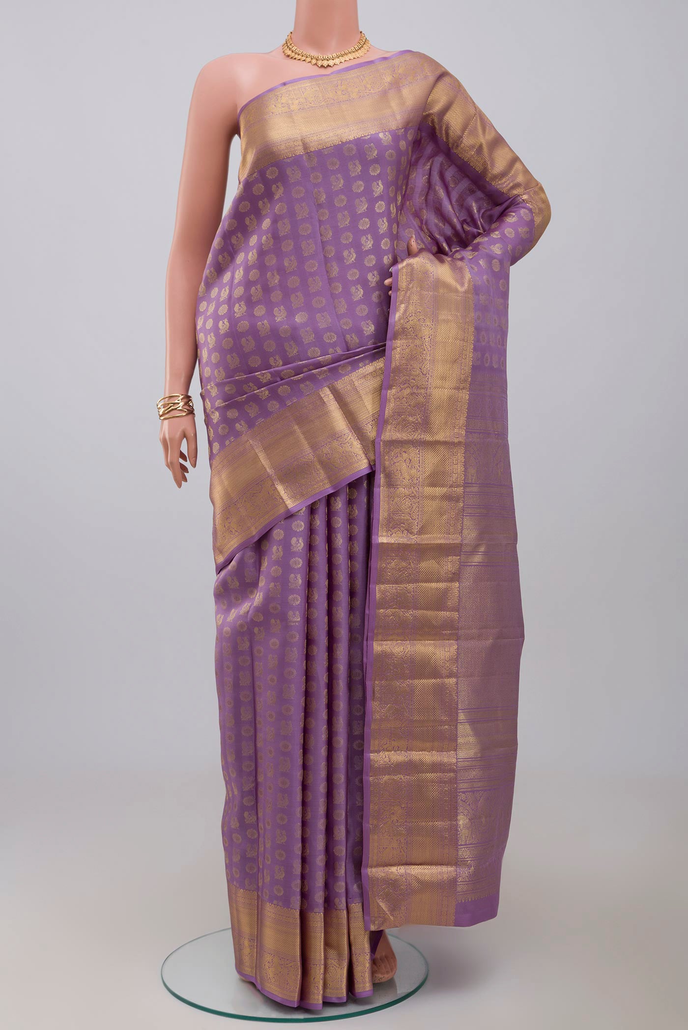Lavender Kanchipuram Saree with Zari Butta on the body and Zari Border.  displayed on a mannequin
