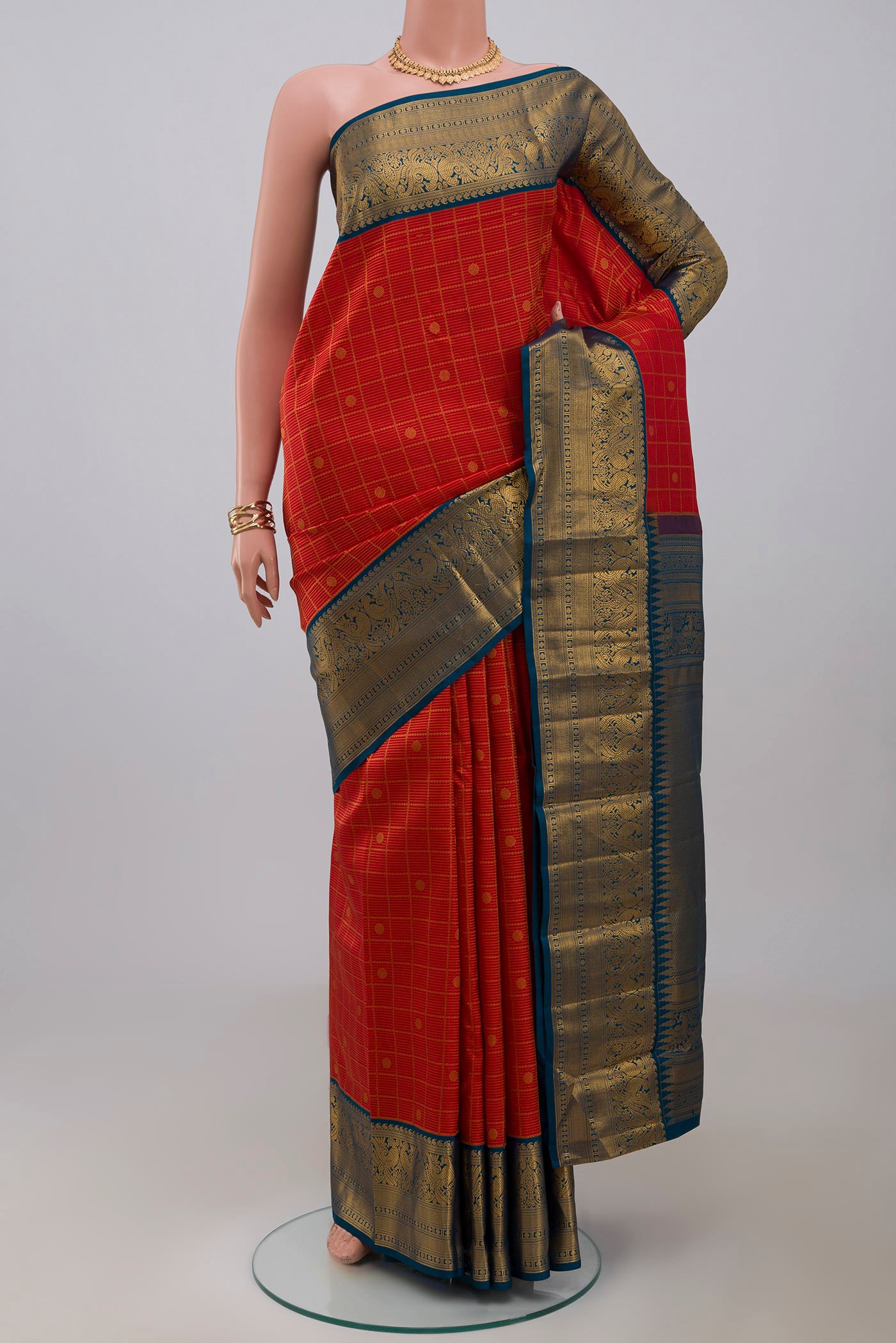 Red Kanjivaram Saree with Zari Brocade on the body and Zari Border.  displayed on a mannequin