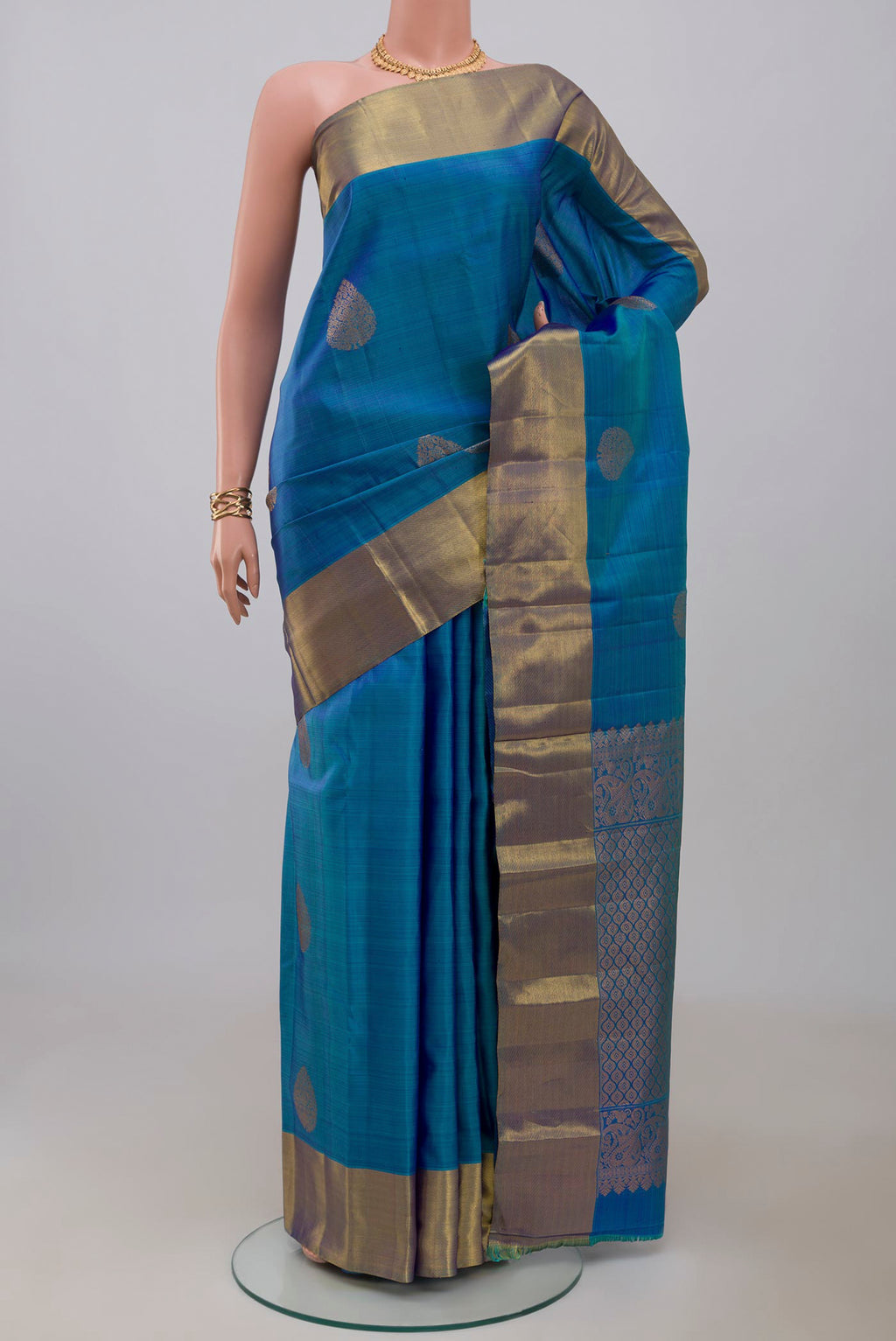 Blue Kanchipuram Silk Saree with Zari Butta on the body and Zari Border.  displayed on a mannequin
