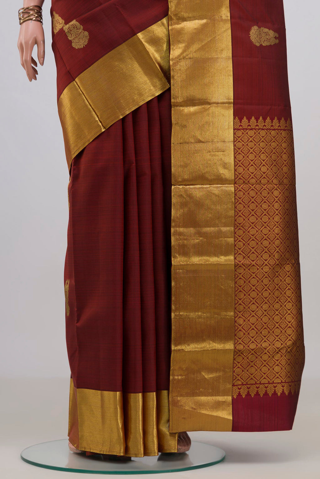 Pleats and pallu of Pure Silk Maroon Kanchipuram Saree with Zari Butta on the body and Zari Border. 