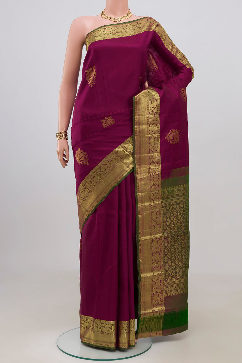 Magenta Kanchipuram Silk Saree with Zari Butta on the body and Zari Border.  displayed on a mannequin