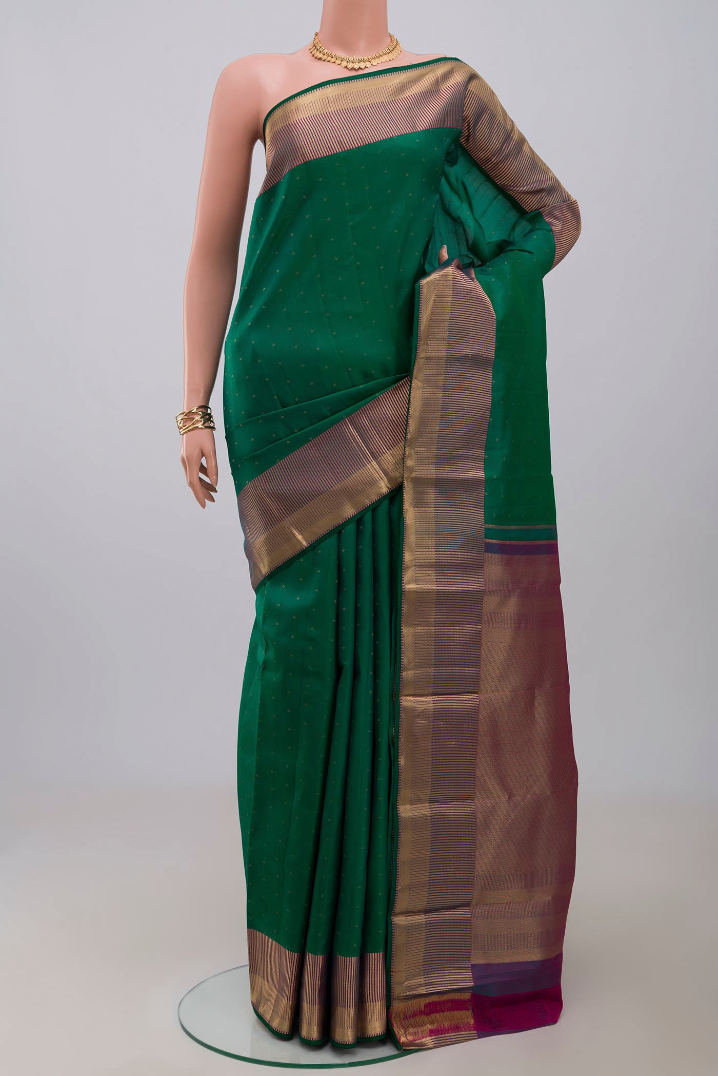 Green Kanchipuram Silk Saree with Zari Butta on the body and Zari Border.  displayed on a mannequin