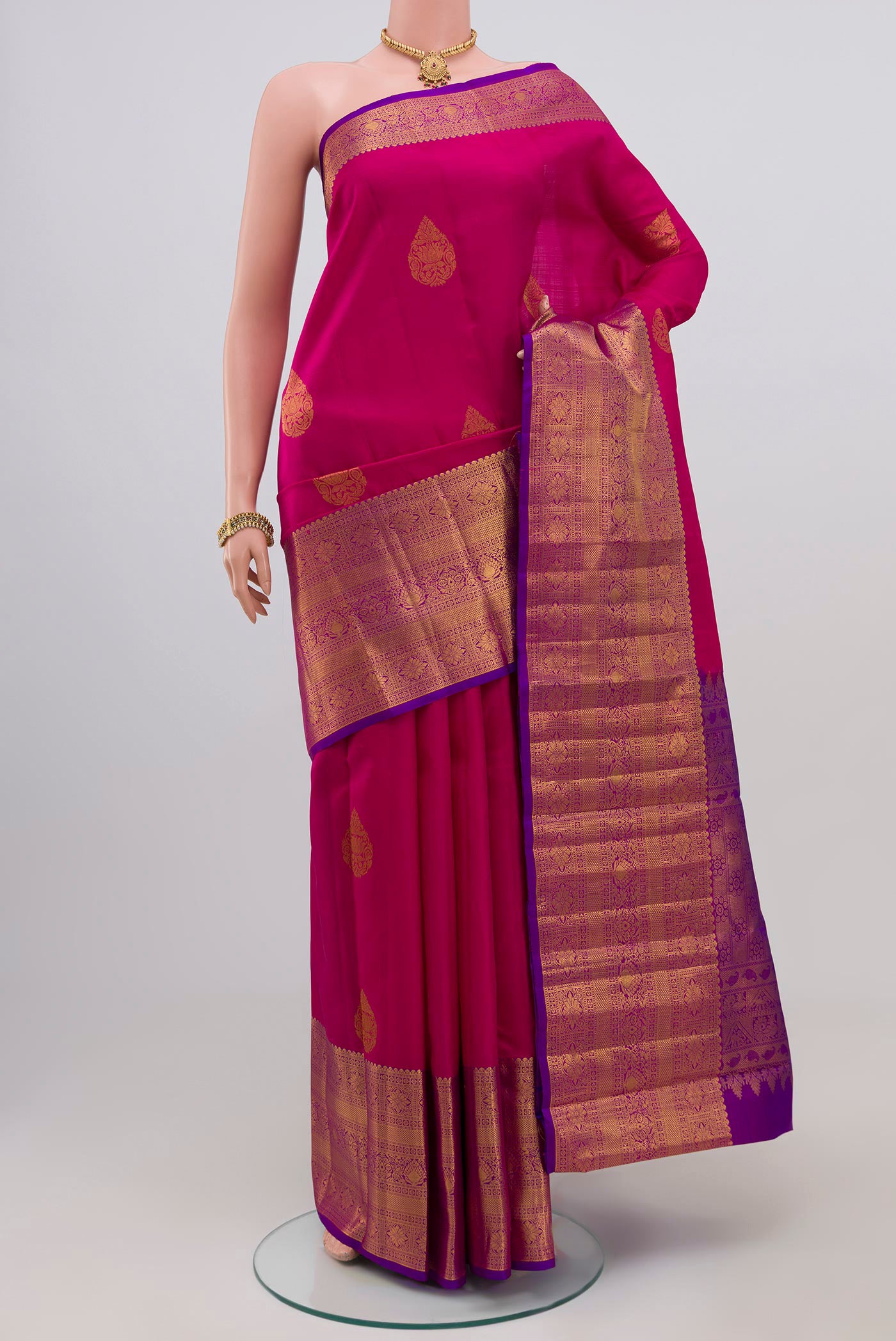 Pink Kanchipuram Silk Saree with Zari Butta on the body and Zari Border.  displayed on a mannequin