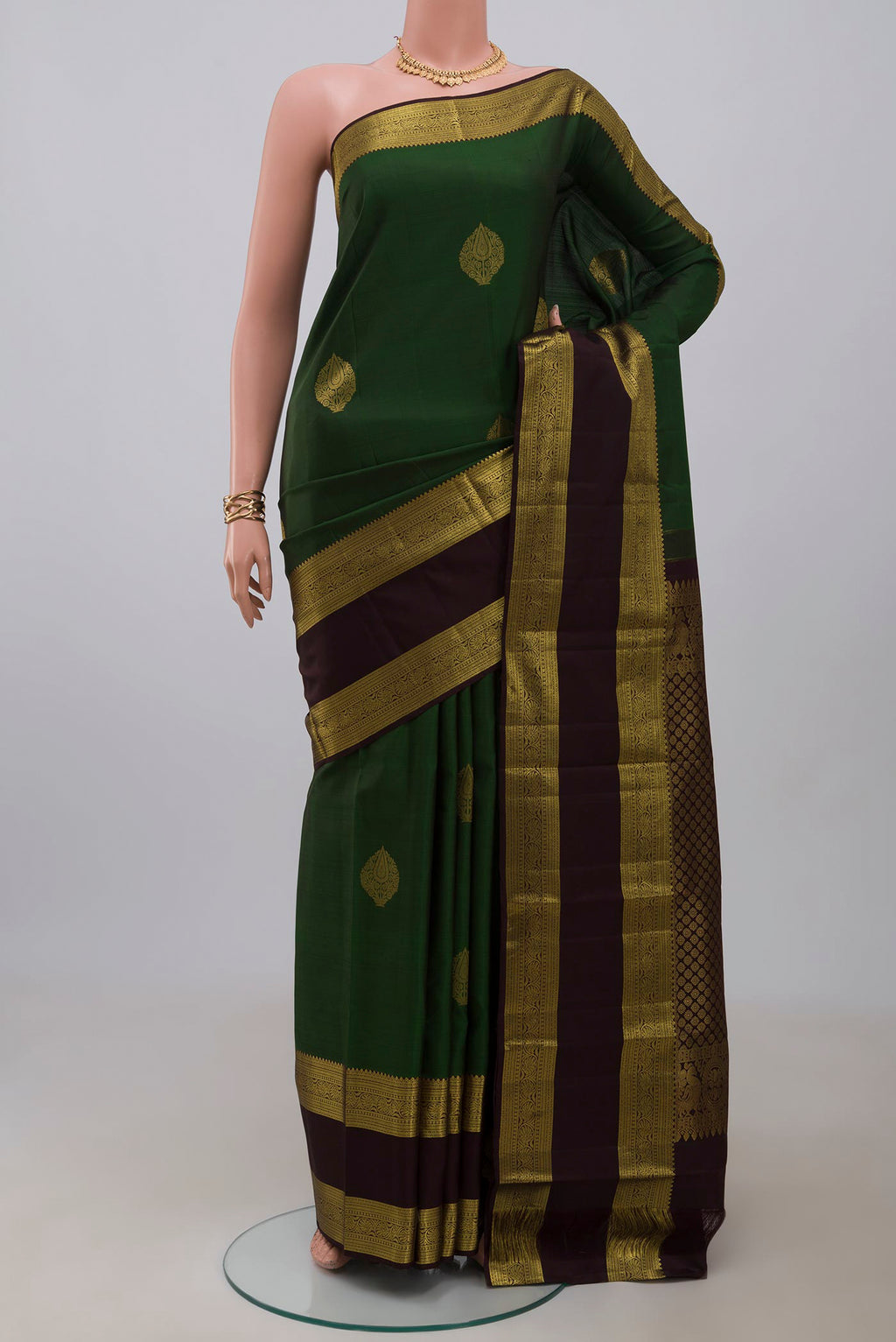 Green Kanchipuram Silk Saree with Zari Butta on the body and Zari Border.  displayed on a mannequin