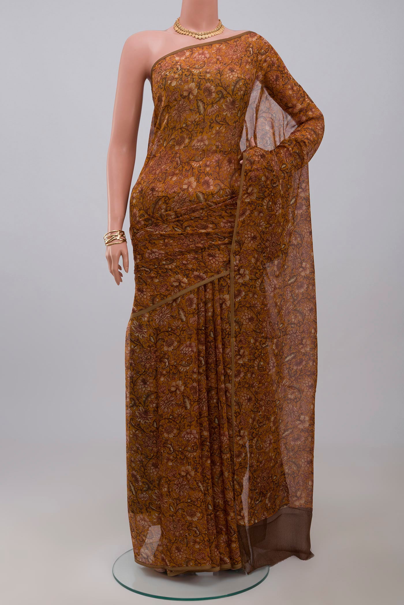 Mustard Chiffon Saree with Printed design on the body and Without Border.  displayed on a mannequin
