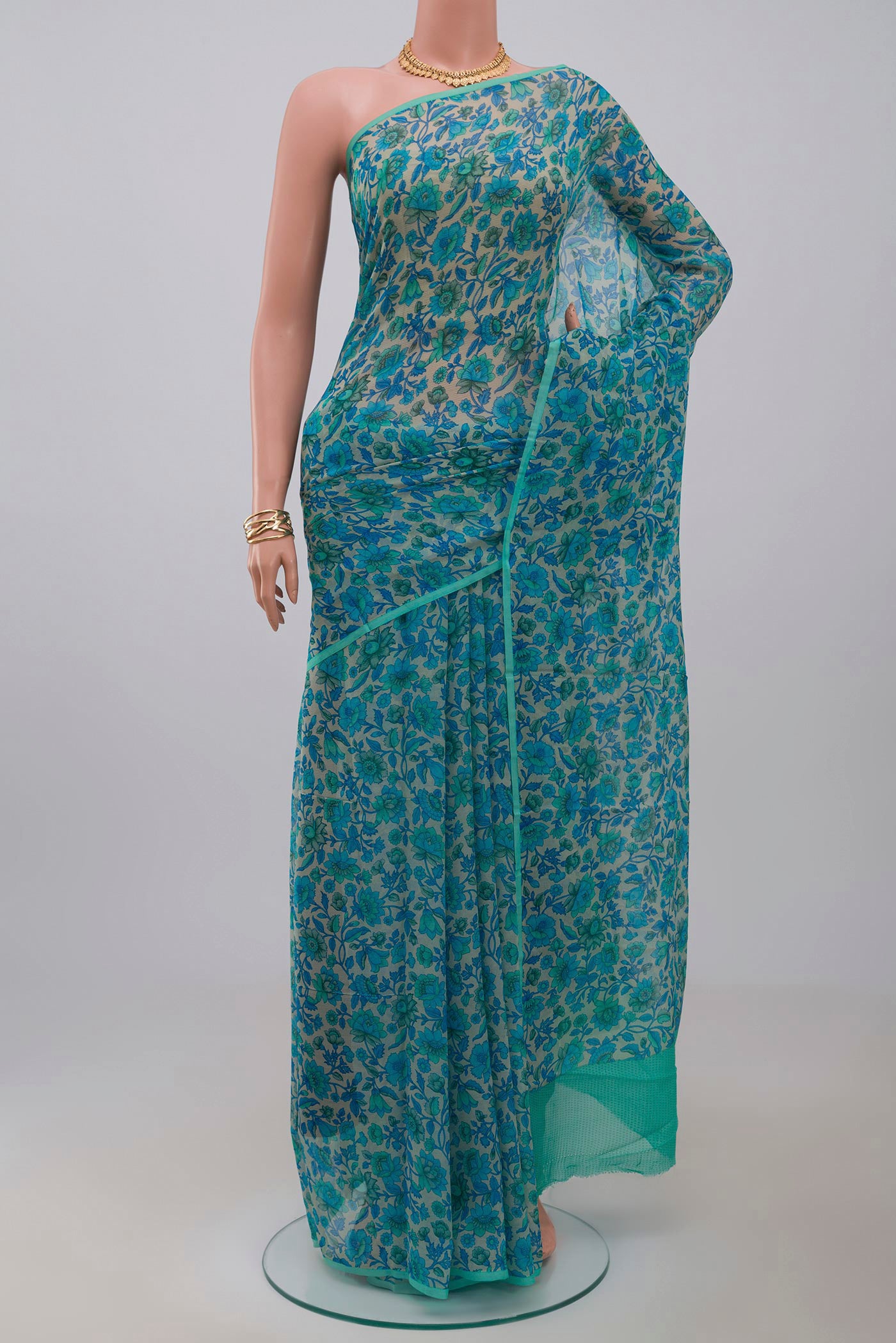 Cream Chiffon Saree with Printed design on the body and Without Border.  displayed on a mannequin