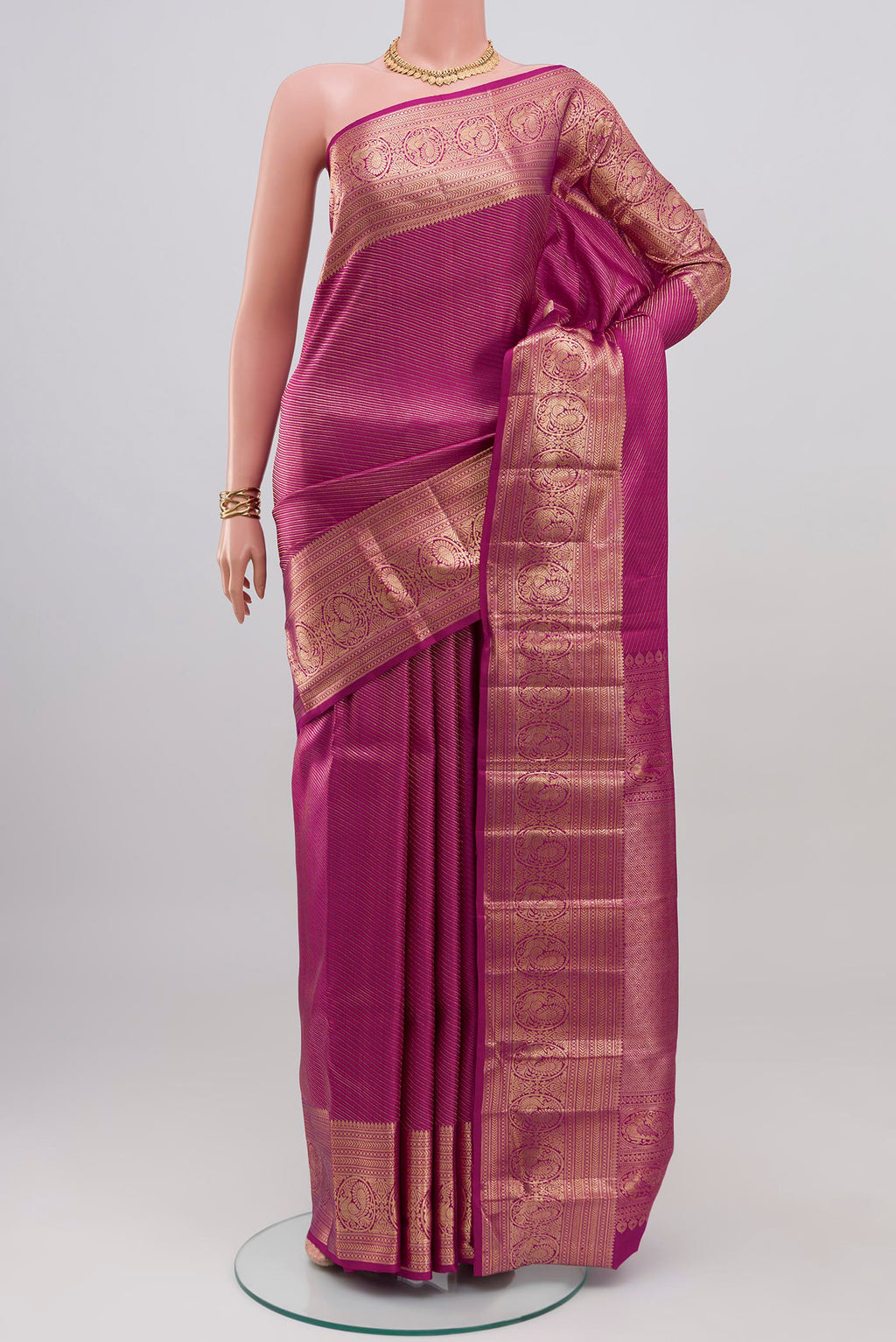 Magenta Kanchipuram Silk Saree with Zari Brocade on the body and Zari Border.  displayed on a mannequin