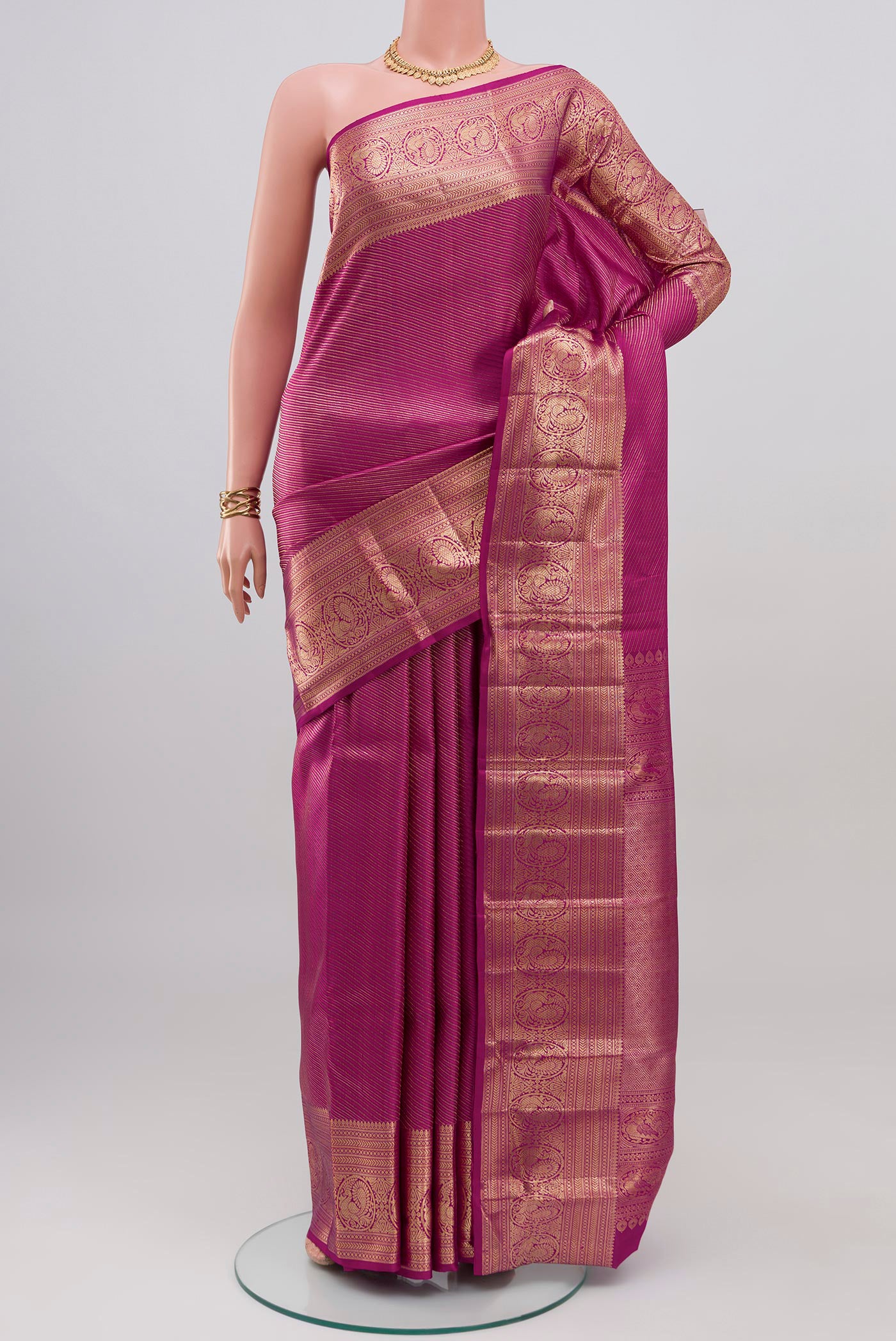 Magenta Kanchipuram Silk Saree with Zari Brocade on the body and Zari Border.  displayed on a mannequin