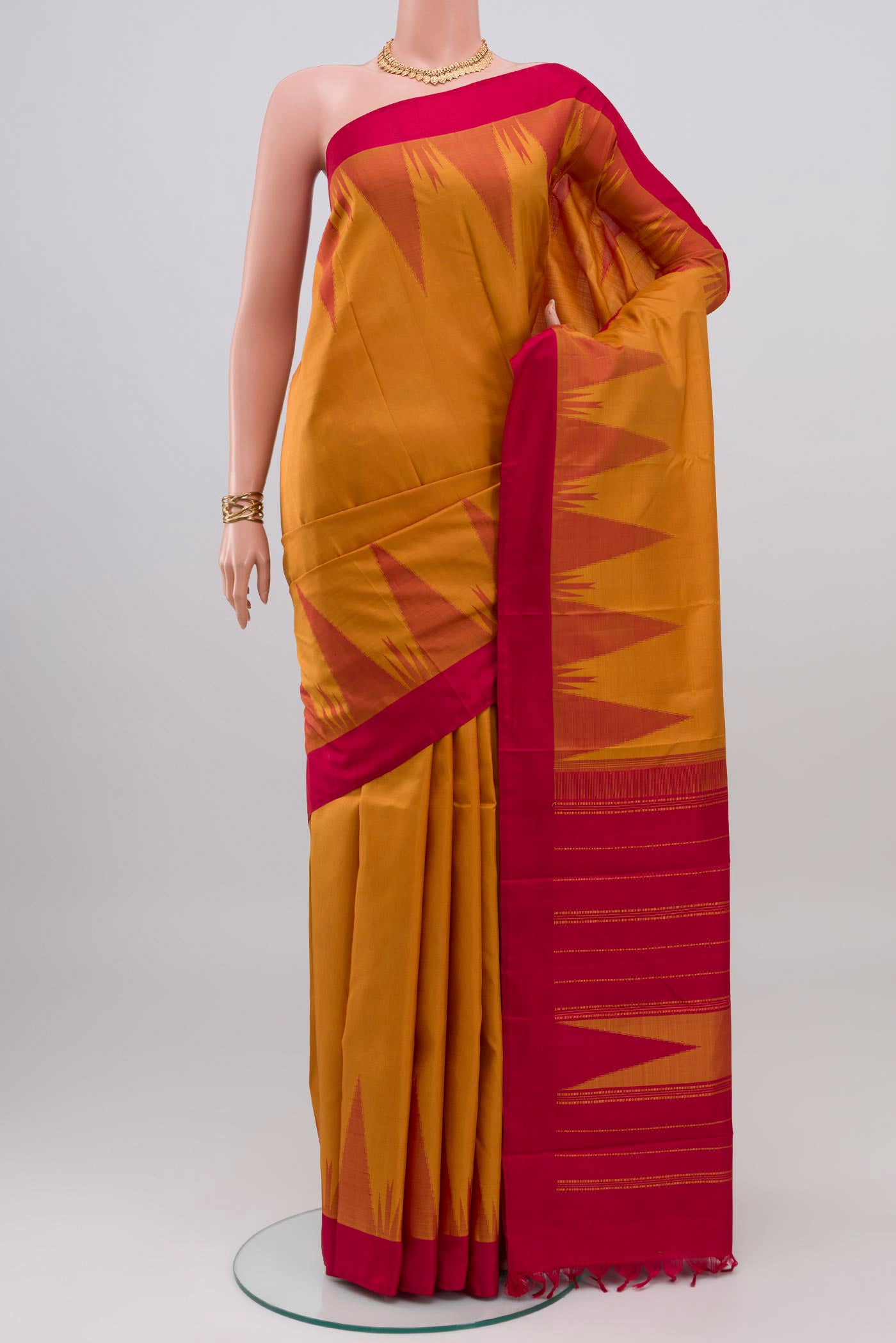 Mustard Kanchipuram Silk Saree with Plain Body and Temple Border.  displayed on a mannequin