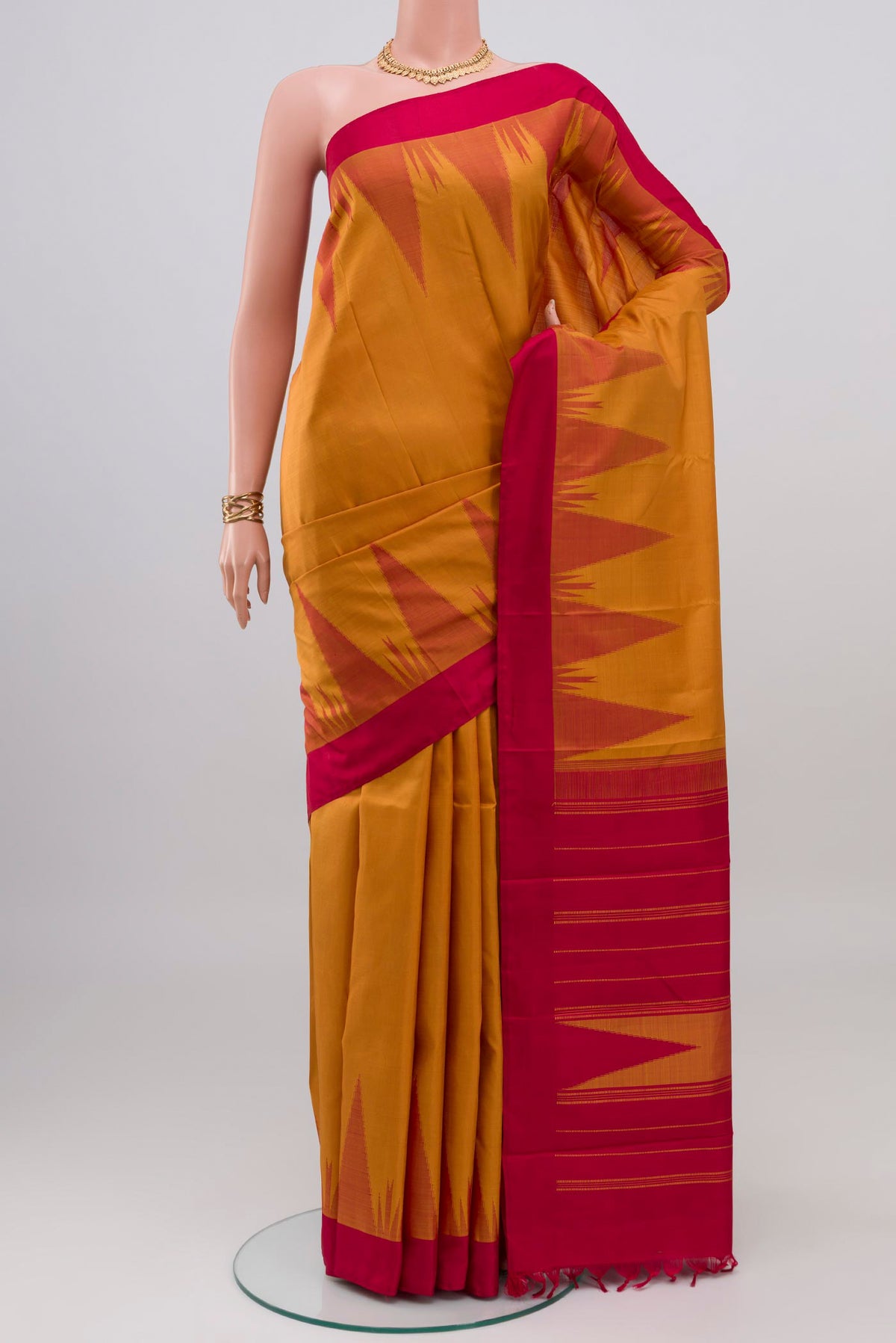 Mustard Kanchipuram Silk Saree with Plain Body and Temple Border.  displayed on a mannequin