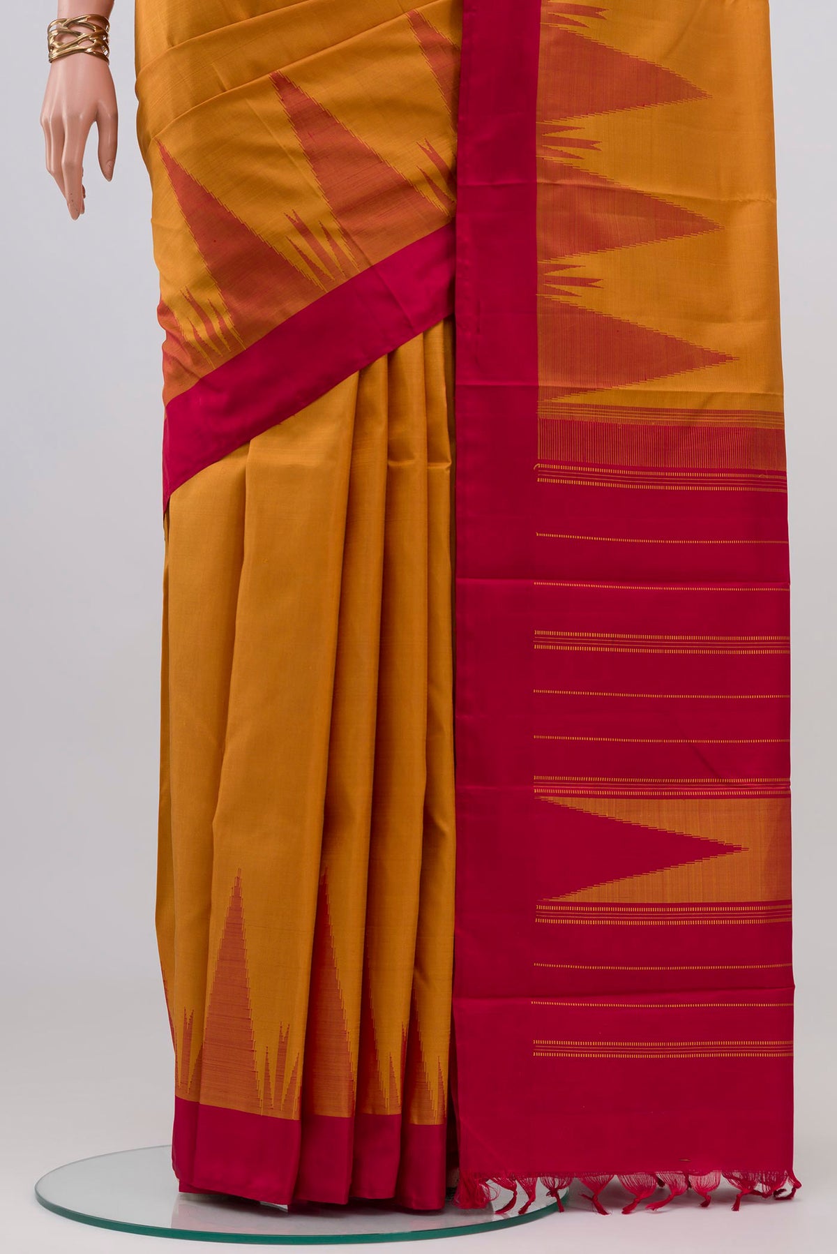 Pleats and pallu of Mustard Kanchipuram Silk Saree with Plain Body and Temple Border. 