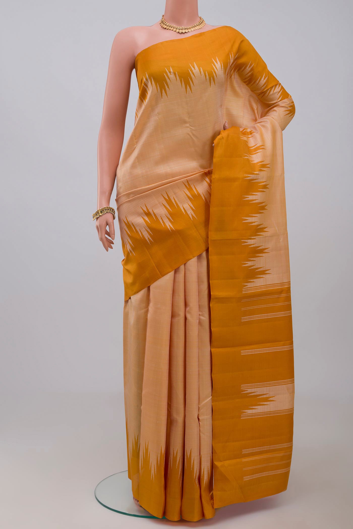 Mustard Kanchipuram Silk Saree with Plain Body and Temple Border.  displayed on a mannequin
