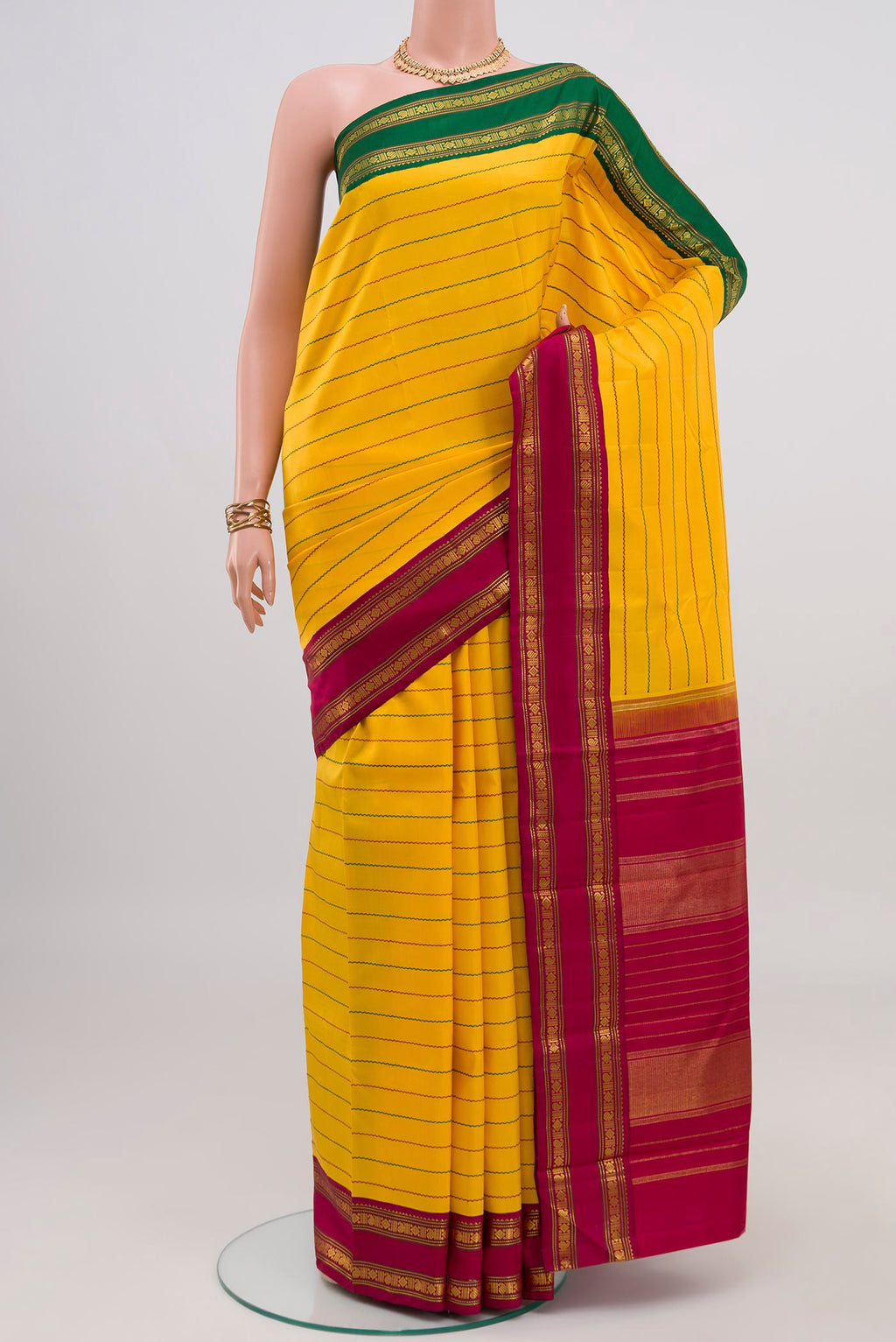 Yellow Kanjivaram Silk Saree with Veldhari on the body and Ganga Jamuna Border.  displayed on a mannequin