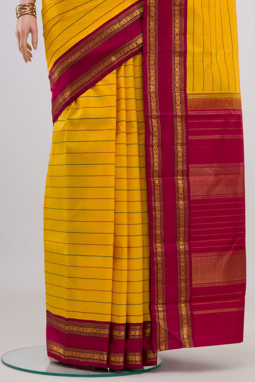 Pleats and pallu of Yellow Kanjivaram Silk Saree with Veldhari on the body and Ganga Jamuna Border. 