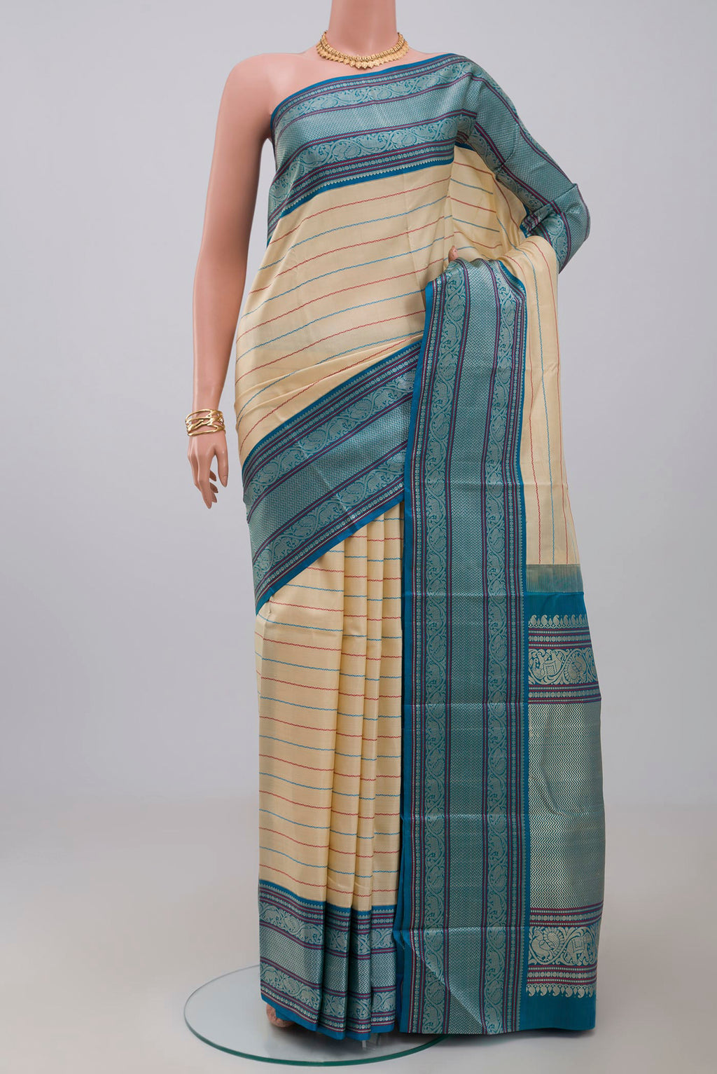 Off White Kanjivaram Silk Saree with Veldhari on the body and Thread Border.  displayed on a mannequin