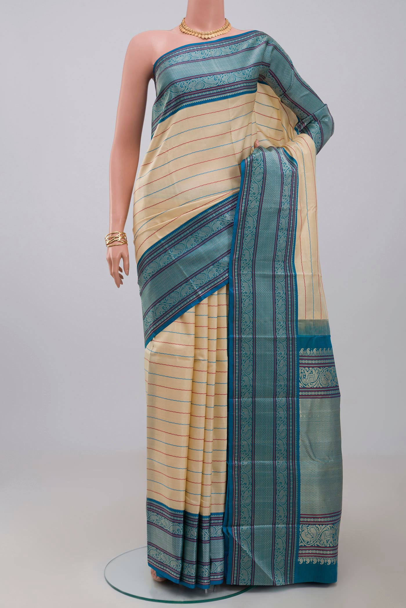 Off White Kanjivaram Silk Saree with Veldhari on the body and Thread Border.  displayed on a mannequin