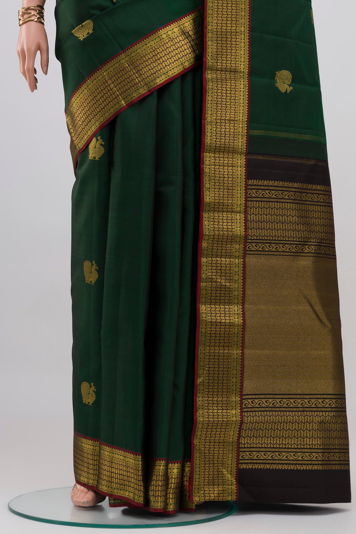 Pleats and pallu of Bottle Green Kanjivaram Silk Saree with Zari Butta on the body and Zari Border. 