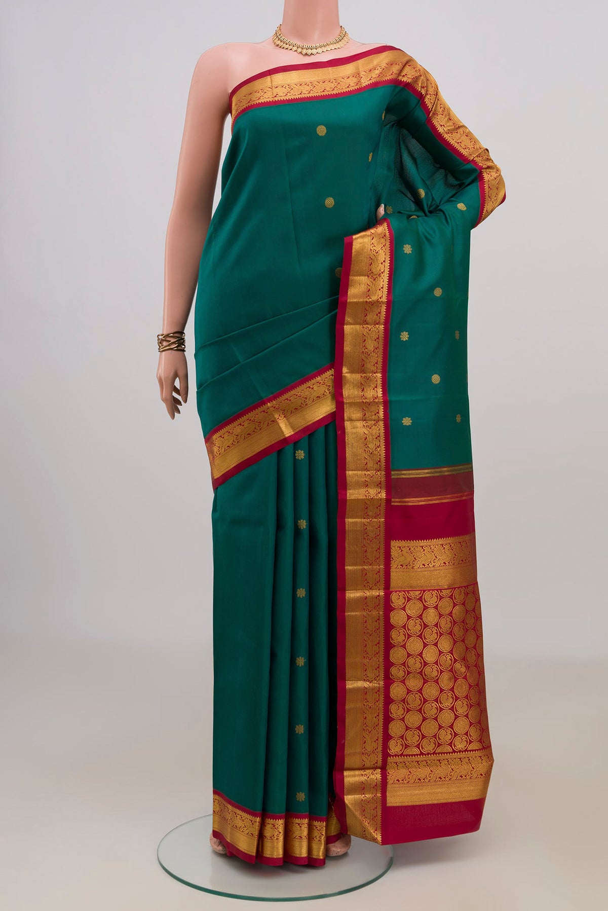 Pure Silk Green Kanchipuram Saree with Zari Butta on the body and Zari Border.  displayed on a mannequin