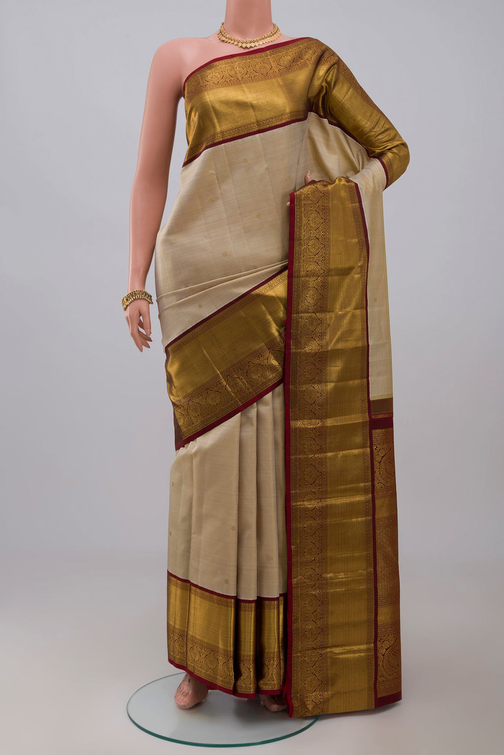 Pure Silk Pure Zari Off White Kanchipuram Saree with Zari Butta on the body and Zari Border.  displayed on a mannequin