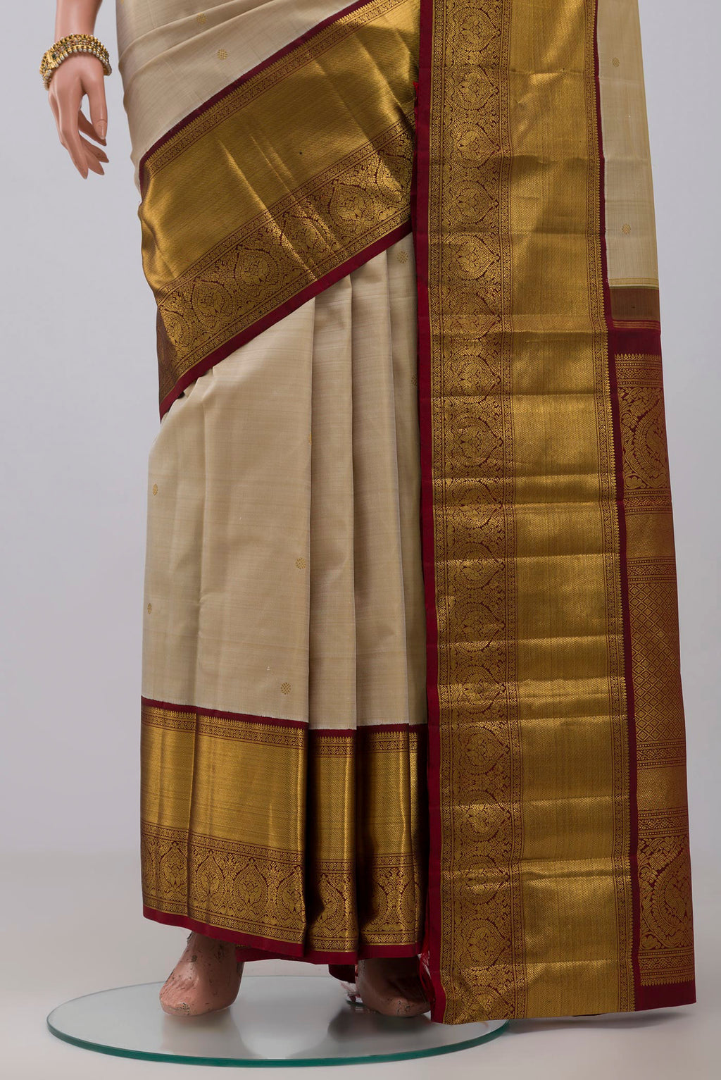 Pleats and pallu of Pure Silk Pure Zari Off White Kanchipuram Saree with Zari Butta on the body and Zari Border. 