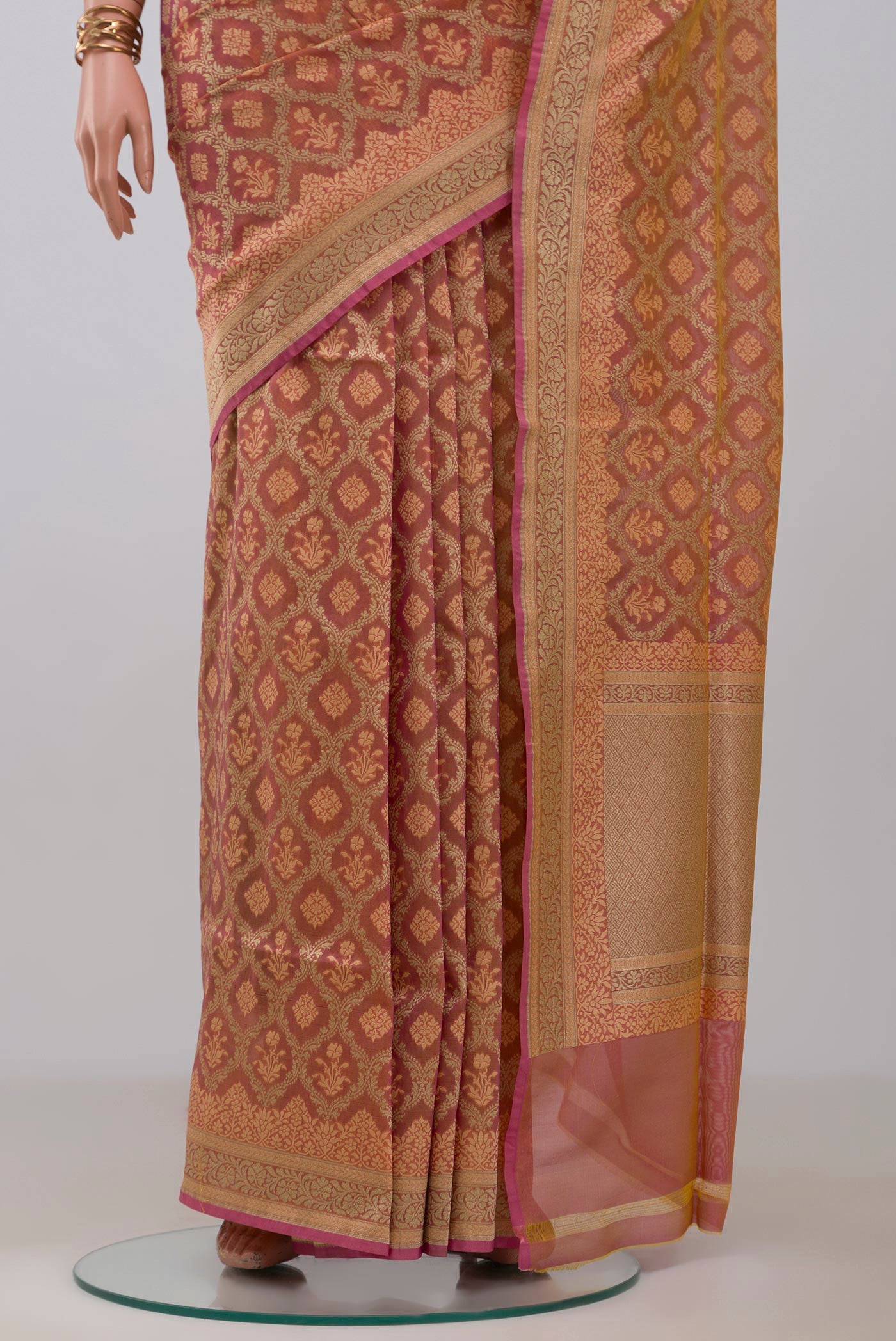 Pleats and pallu of Peach Banarasi Silk Saree with Zari And Thread Butta on the body and Zari Border. 