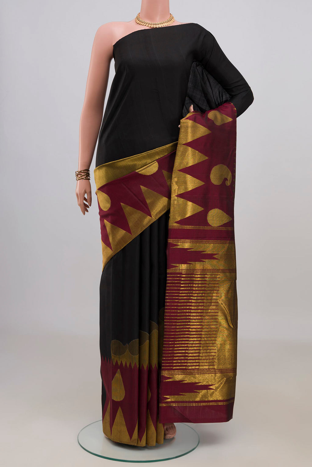 Pure Silk Black Kanchipuram Saree with Plain Body and Temple Border.  displayed on a mannequin