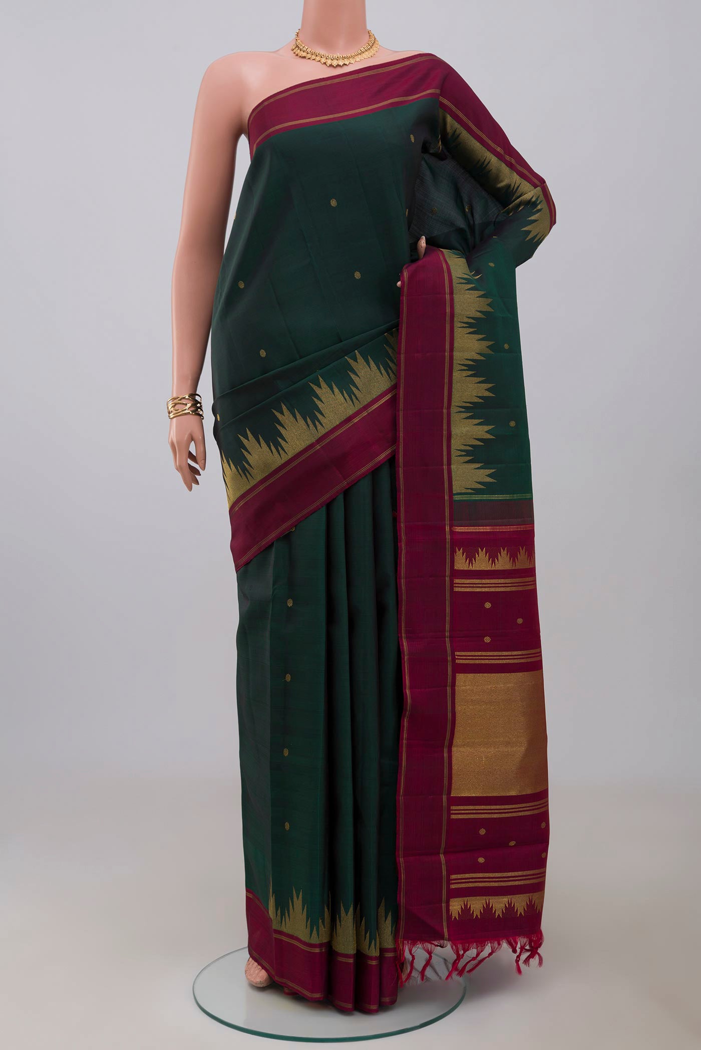 Pure Silk Pure Zari Green Kanchipuram Saree with Zari Butta on the body and Thin Zari Line.  displayed on a mannequin