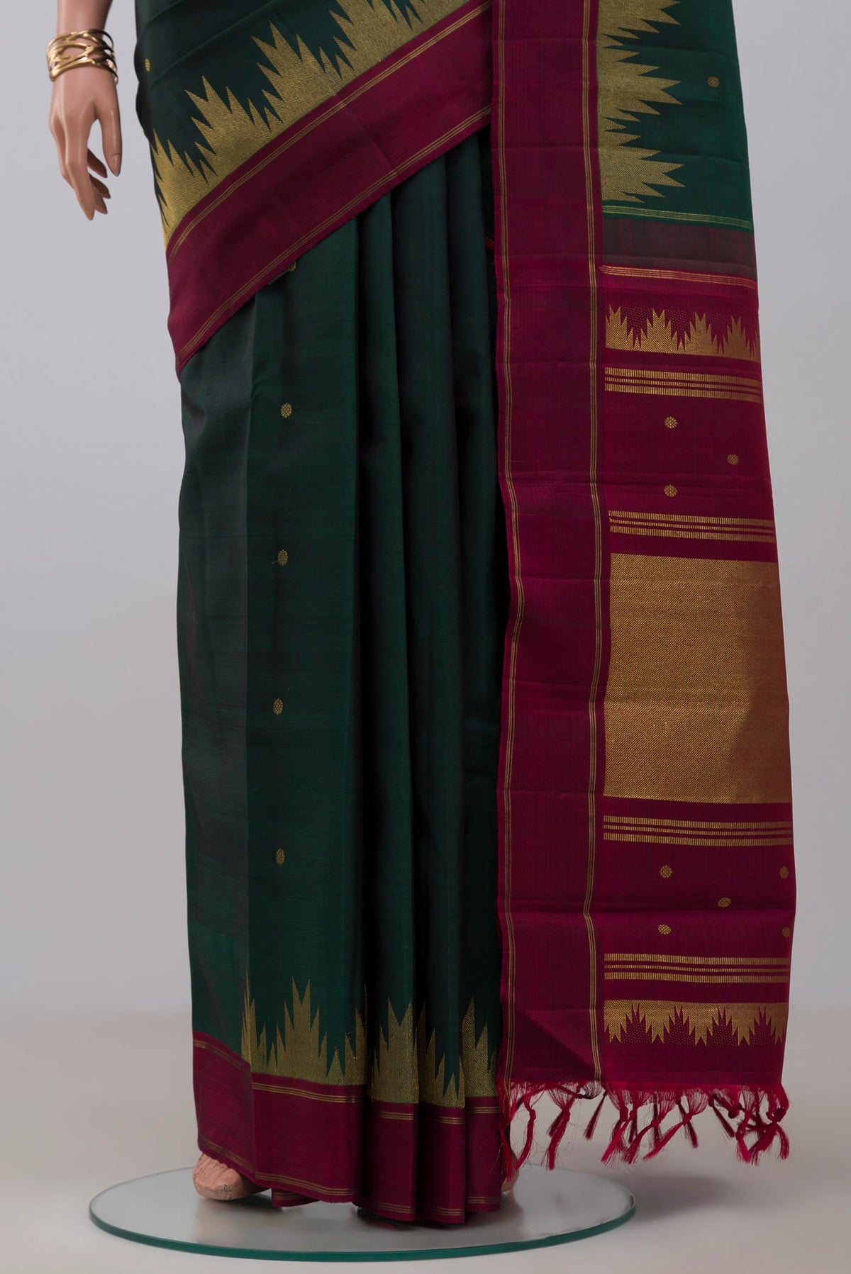 Pleats and pallu of Pure Silk Pure Zari Green Kanchipuram Saree with Zari Butta on the body and Thin Zari Line. 