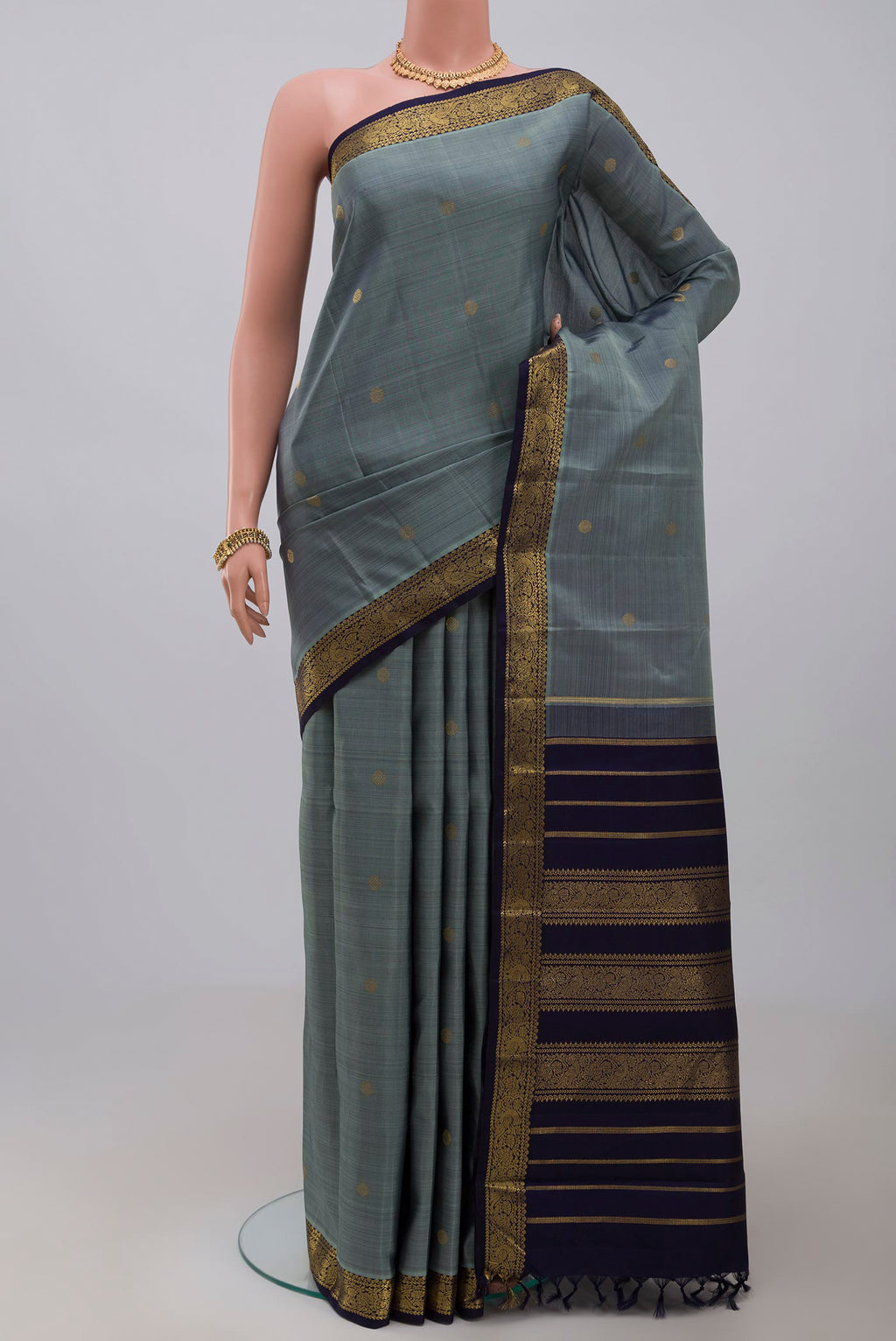Pure Silk Pure Zari Grey Kanchipuram Saree with Zari Butta on the body and Zari Border.  displayed on a mannequin