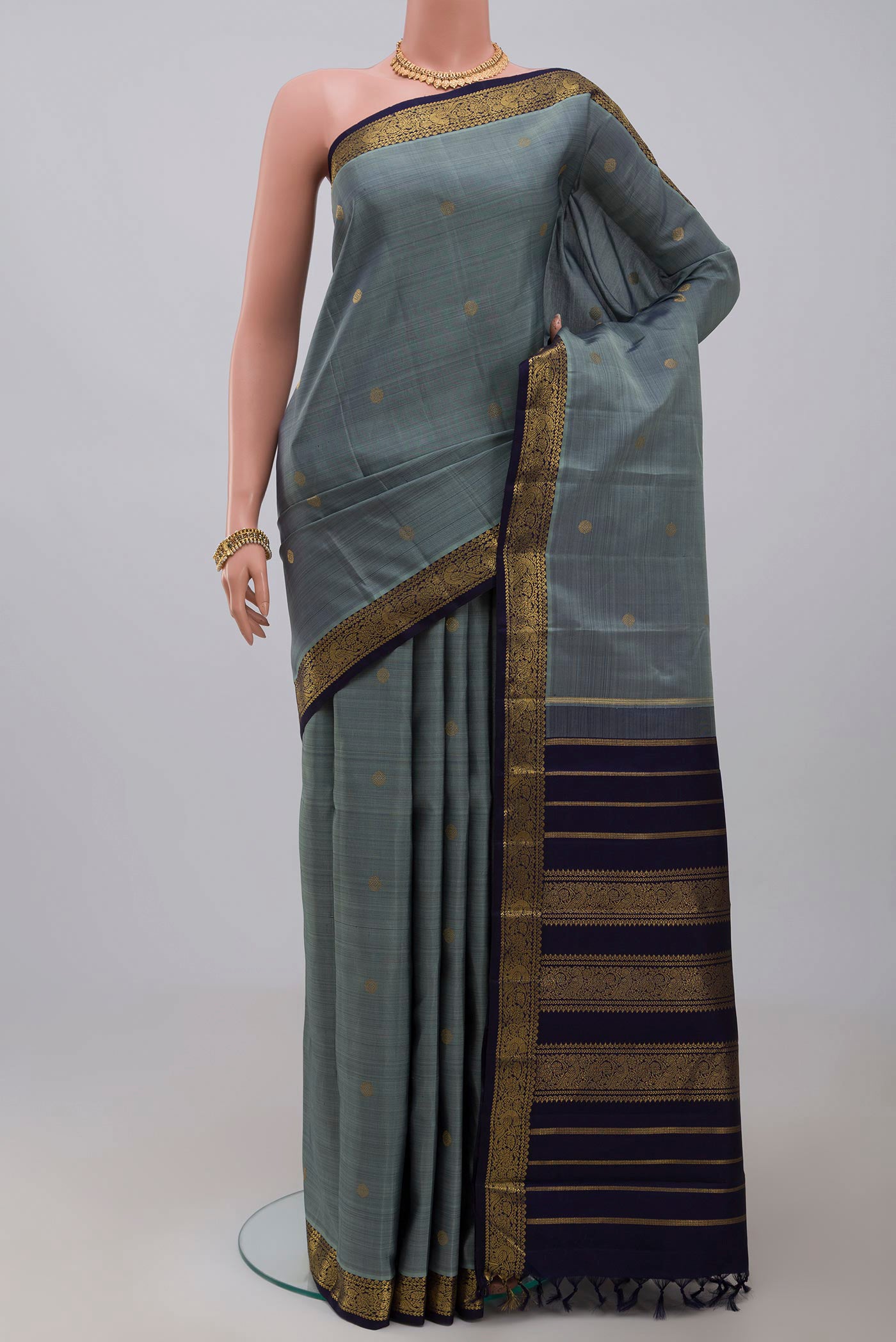 Pure Silk Pure Zari Grey Kanchipuram Saree with Zari Butta on the body and Zari Border.  displayed on a mannequin